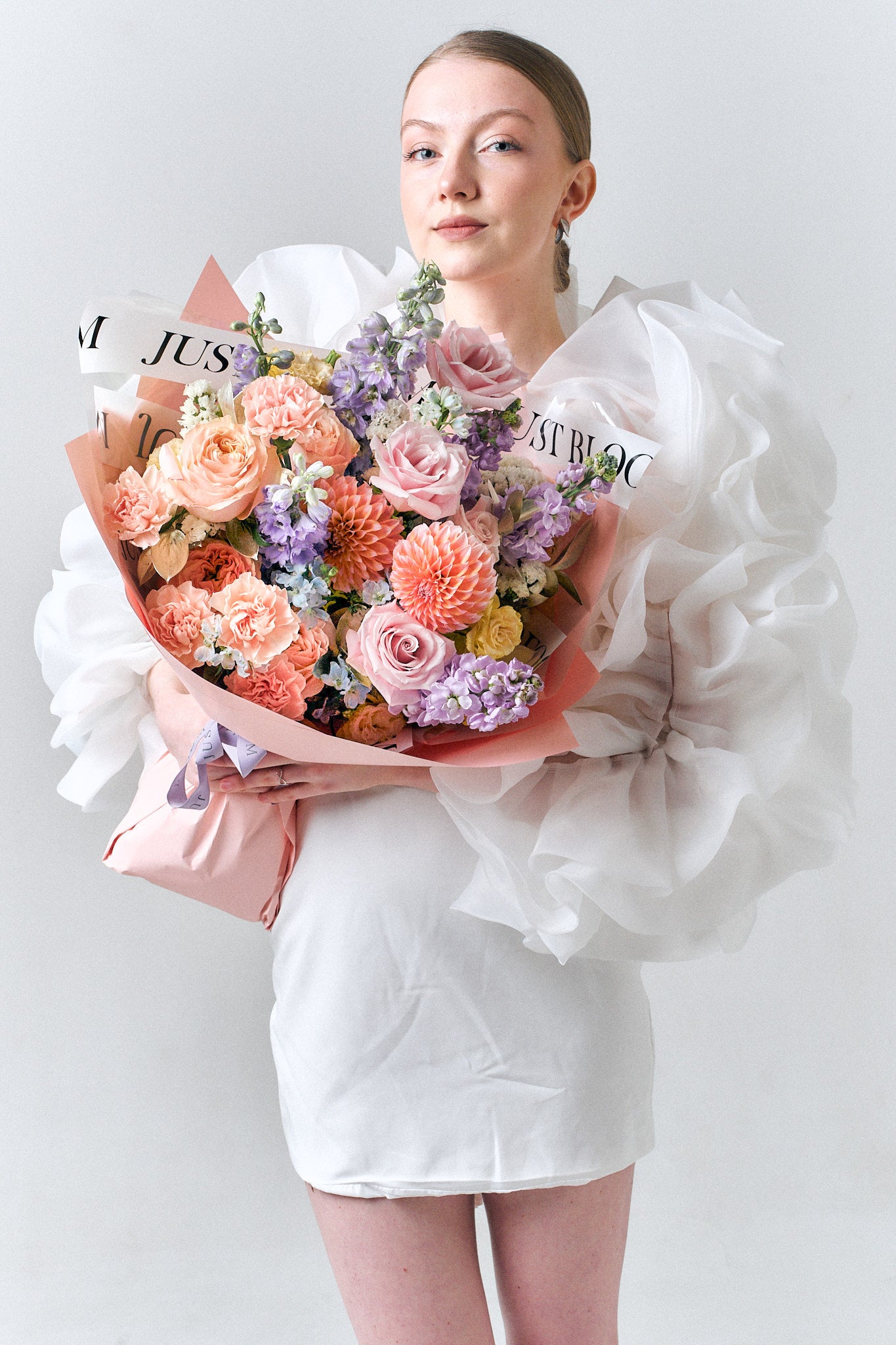 Sweet Encounter pastel bouquet featuring peach roses, lilac stock, and dahlias in soft romantic hues