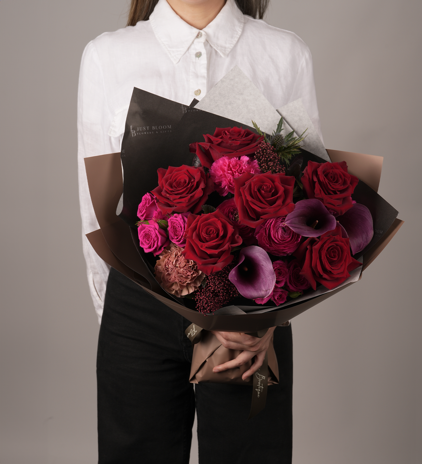 Woman holding Cameron Bouquet with red roses and purple calla lilies