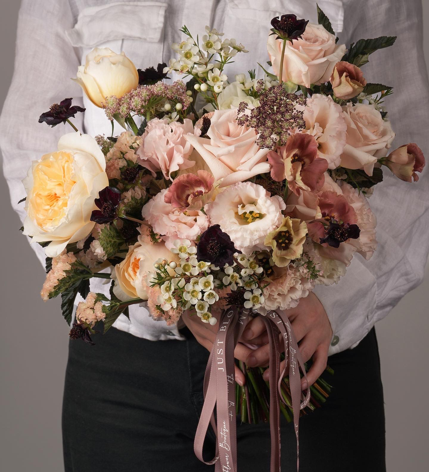 holding Matilda vintage peach and brown bridal bouquet with garden roses, anemones, and eustomas
