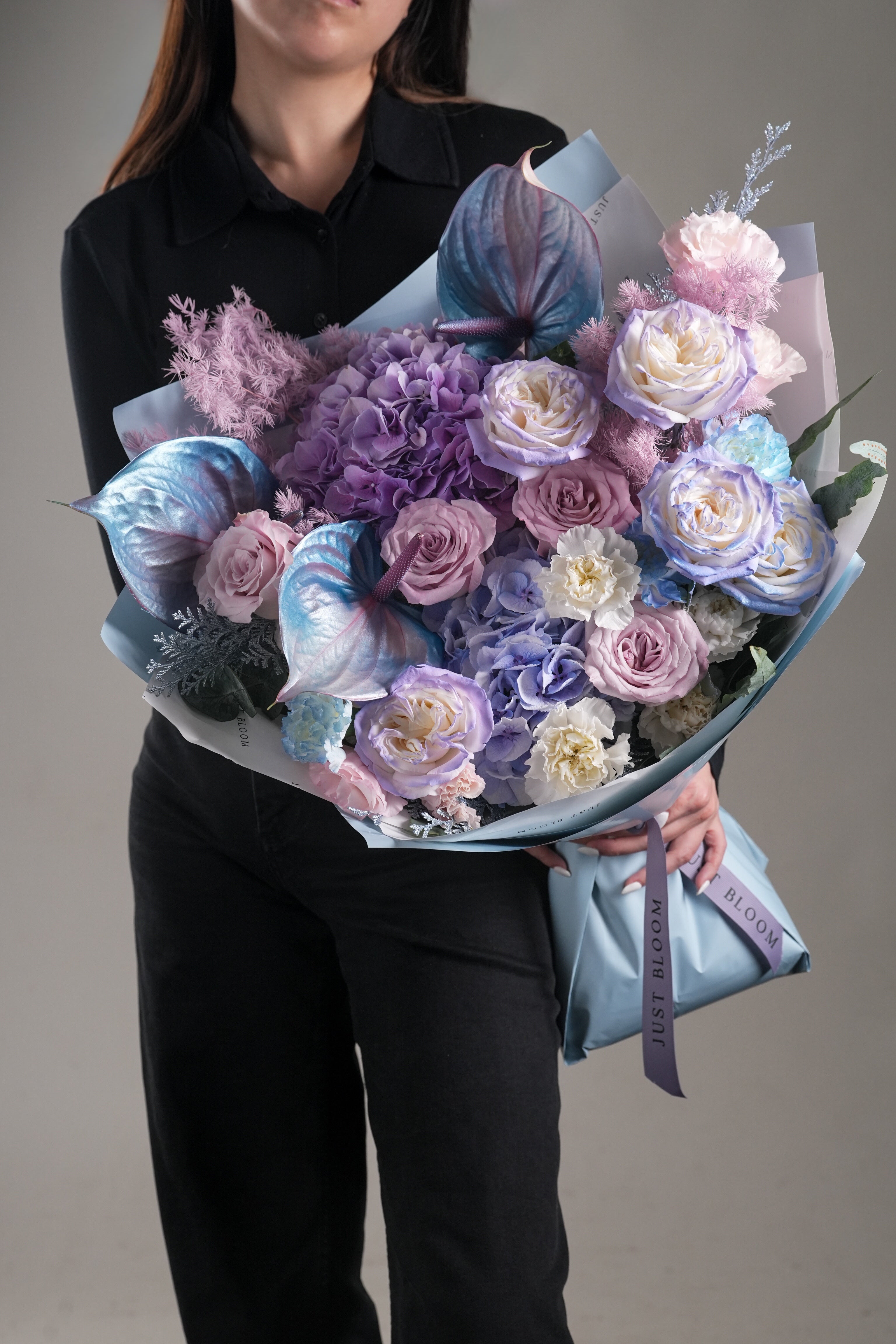 Alia dreamy lavender and pastel blue flower bouquet held by model – Just Bloom