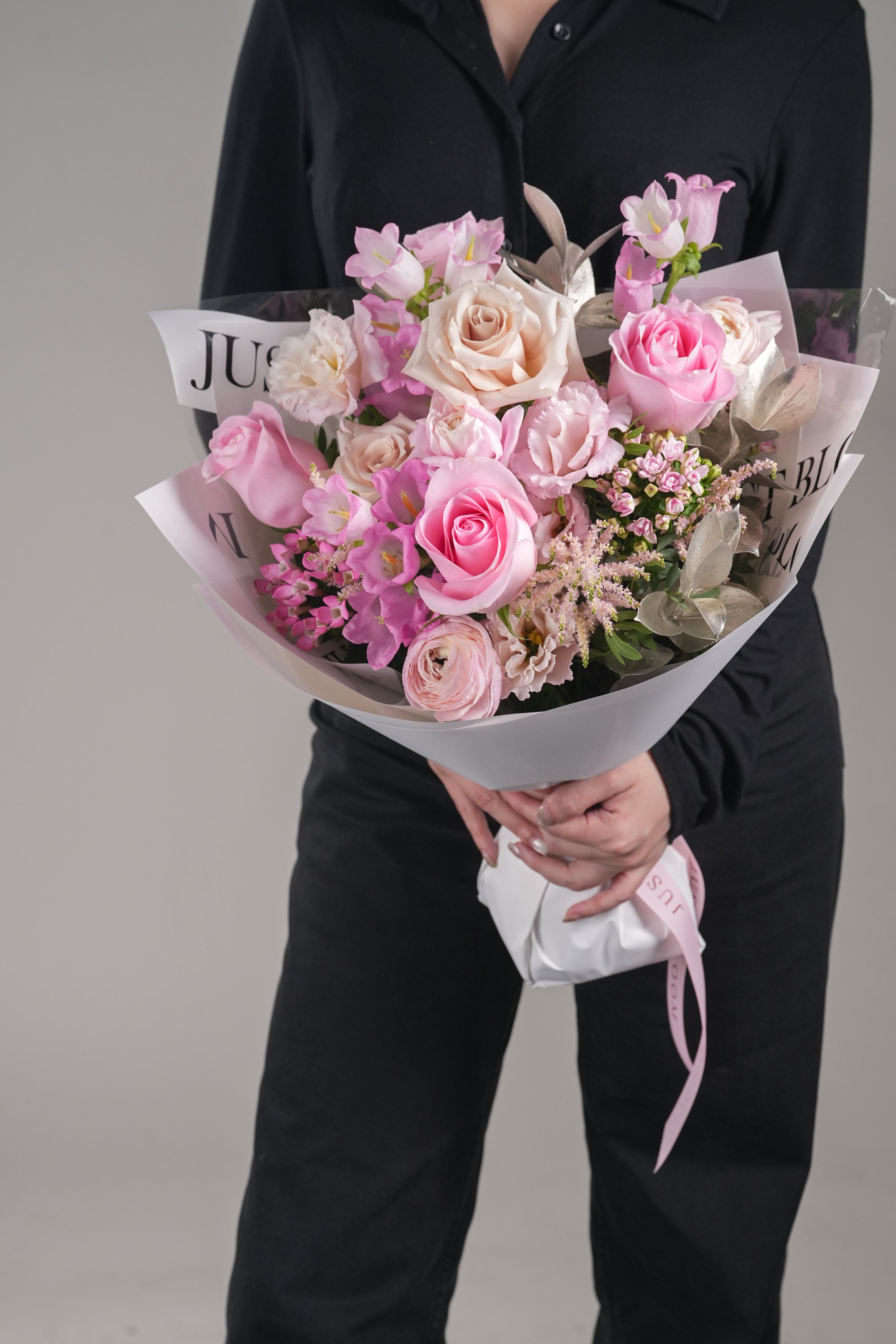 Cadence pink bouquet held by model – pastel Ecuador roses and ranunculus