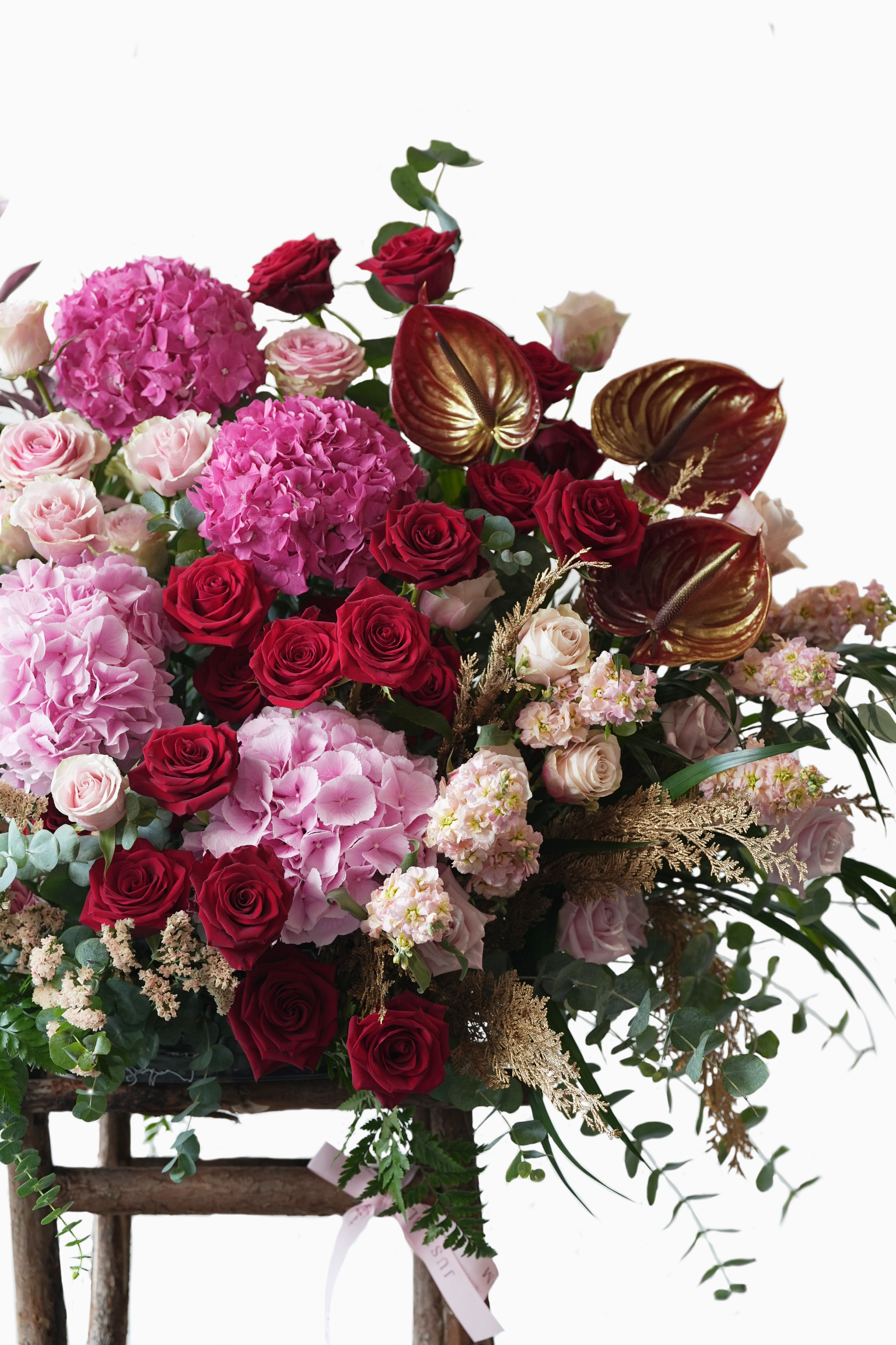 Luxurious pink and red grand opening flower arrangement with golden tropical accents