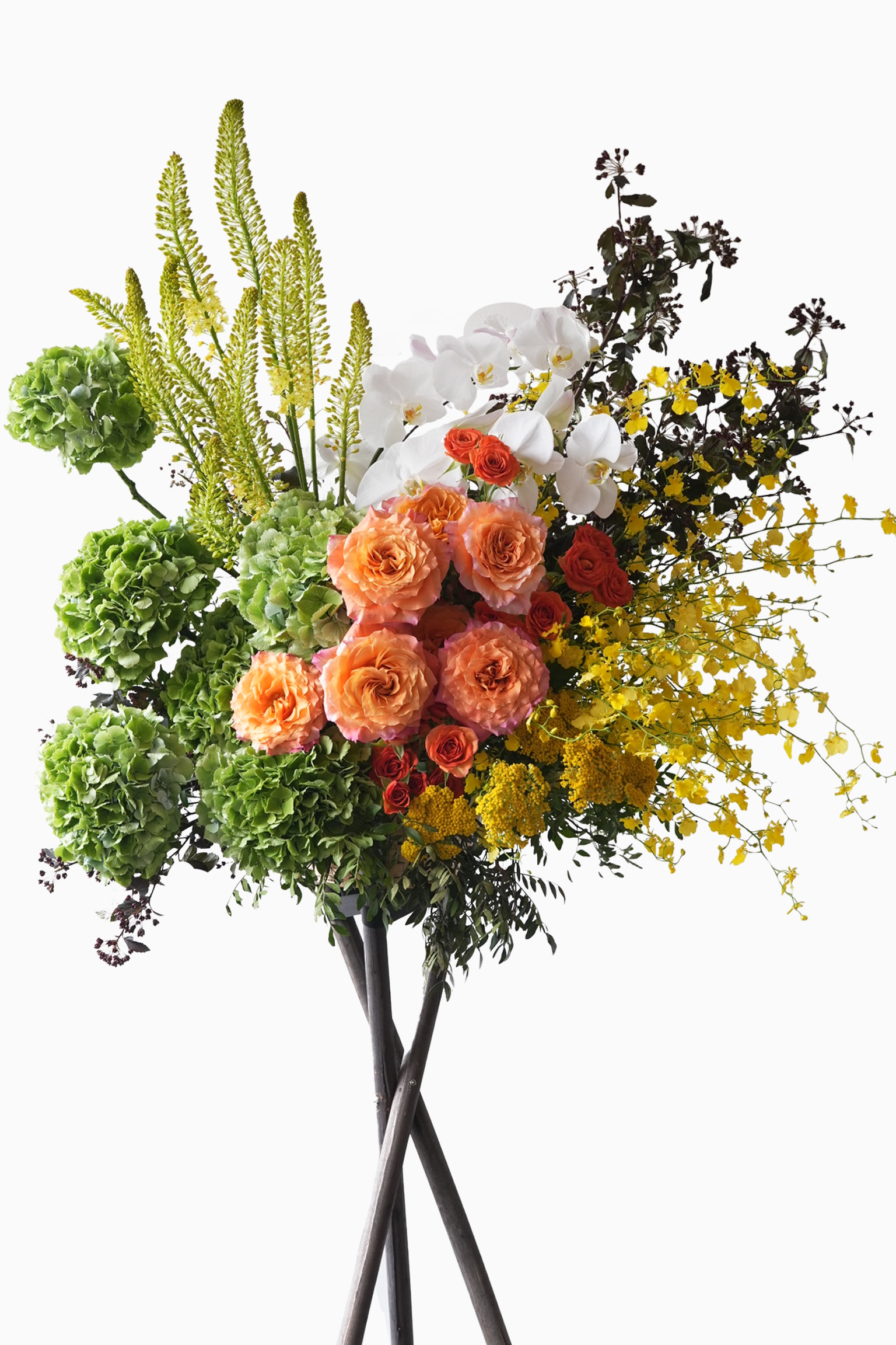 Cheyenne vibrant flower stand – coral Ecuadorian roses with white moth orchids, yellow oncidiums and green fillers on black crossed legs stand.
