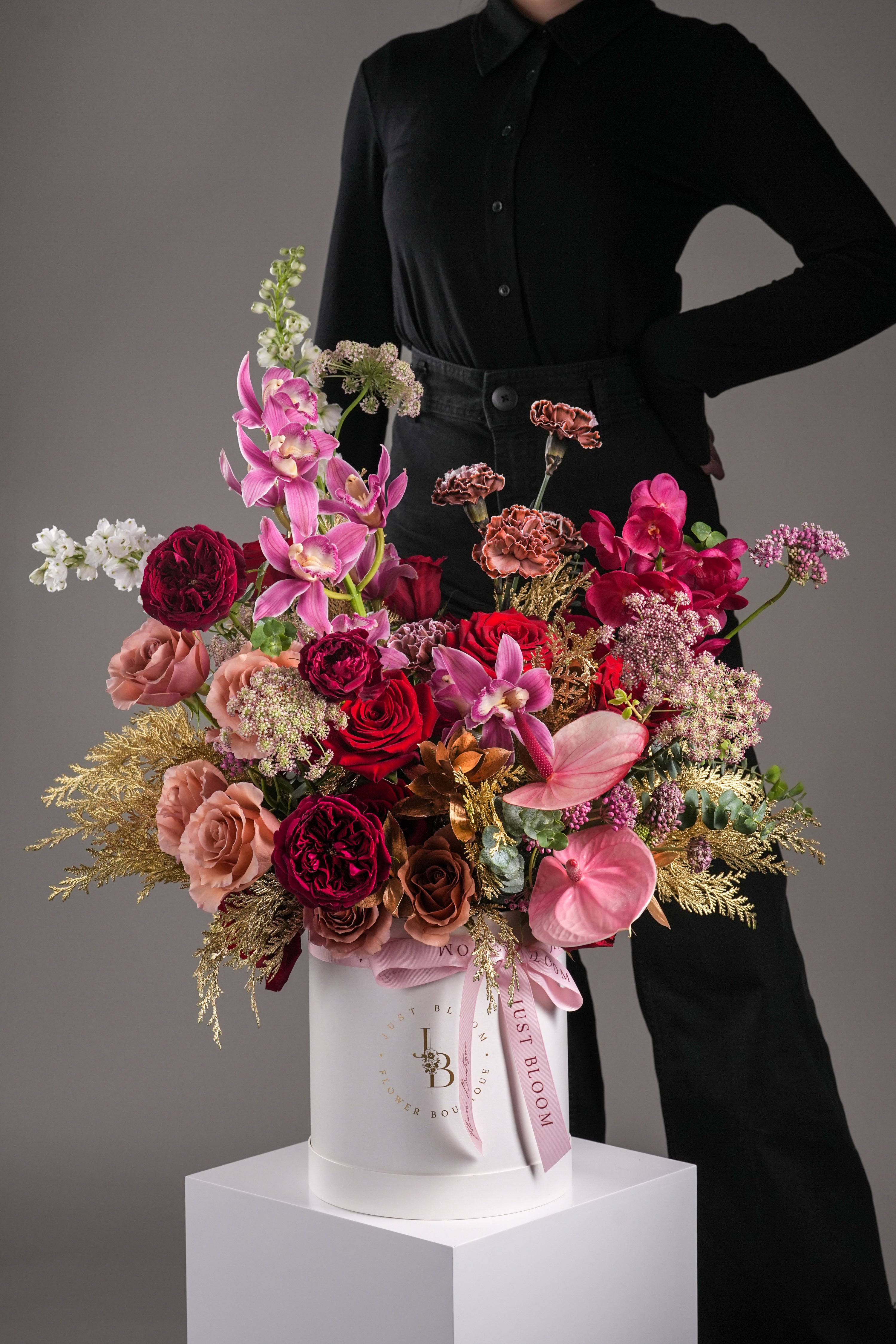 Claire – Oversized celebration flower box in bold red and gold with model holding