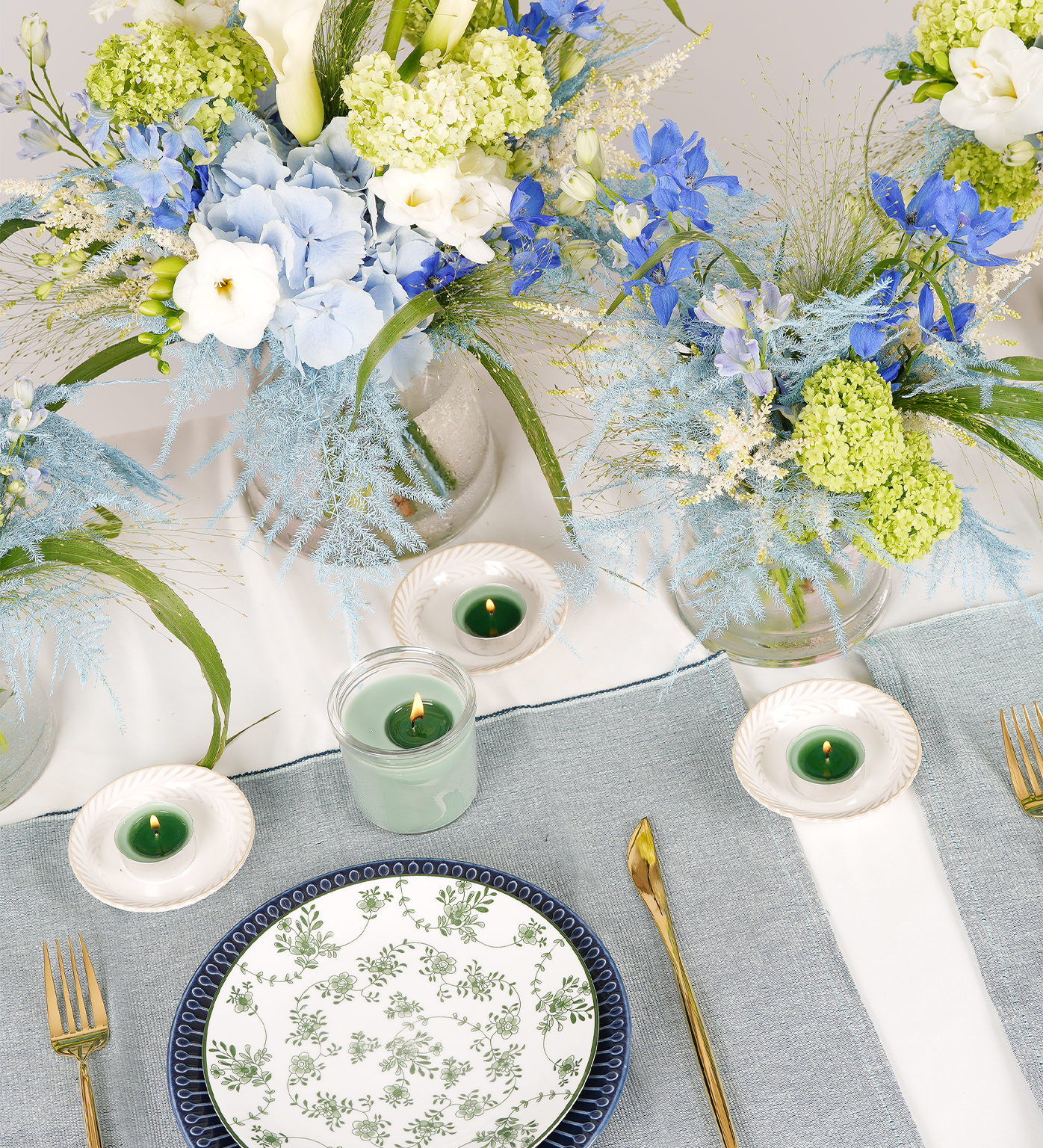 Blue-toned floral styling with fine tableware and candles – Collins by Just Bloom