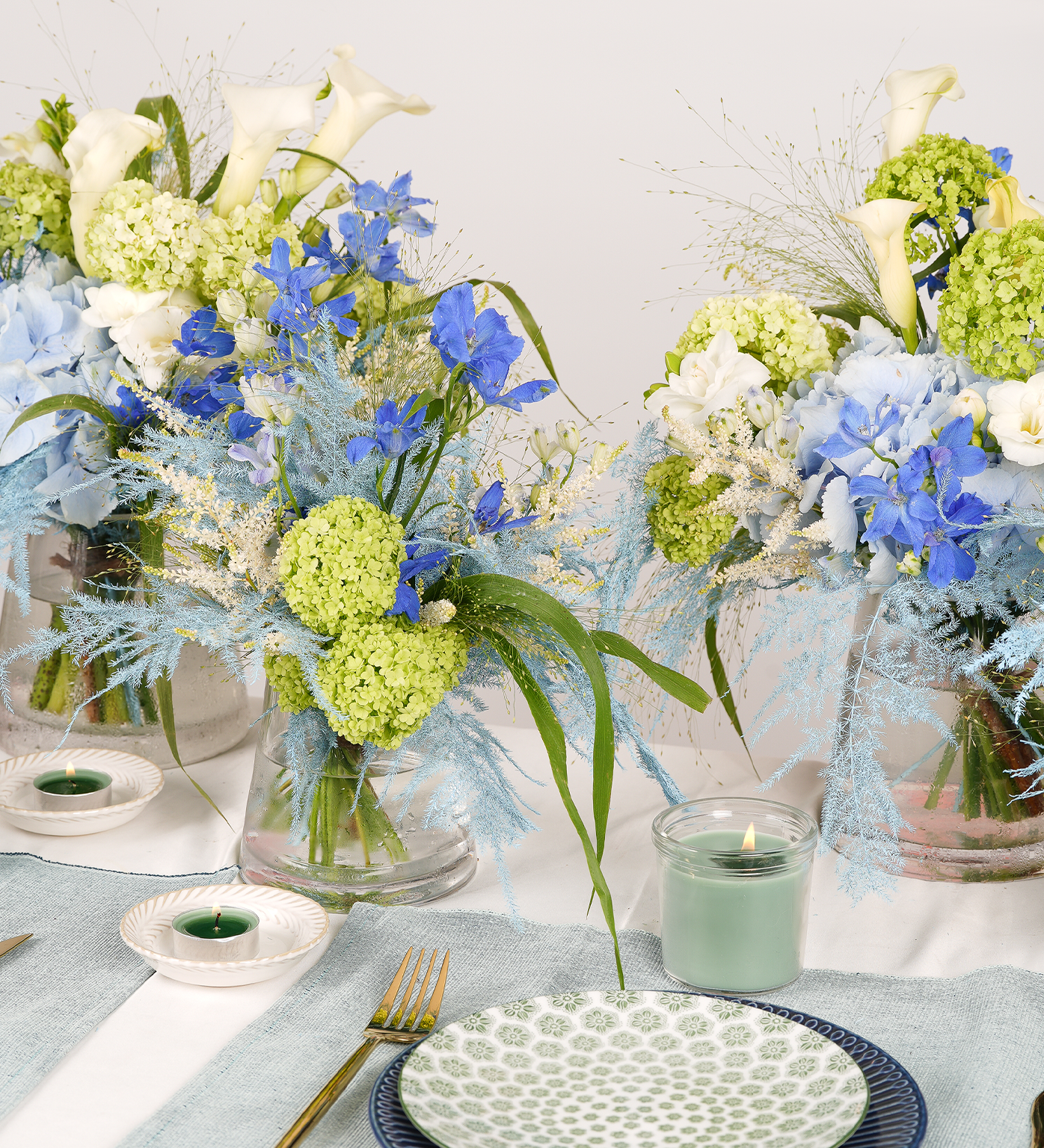 Close-up of blue delphinium and green viburnum table flower arrangement – Just Bloom
