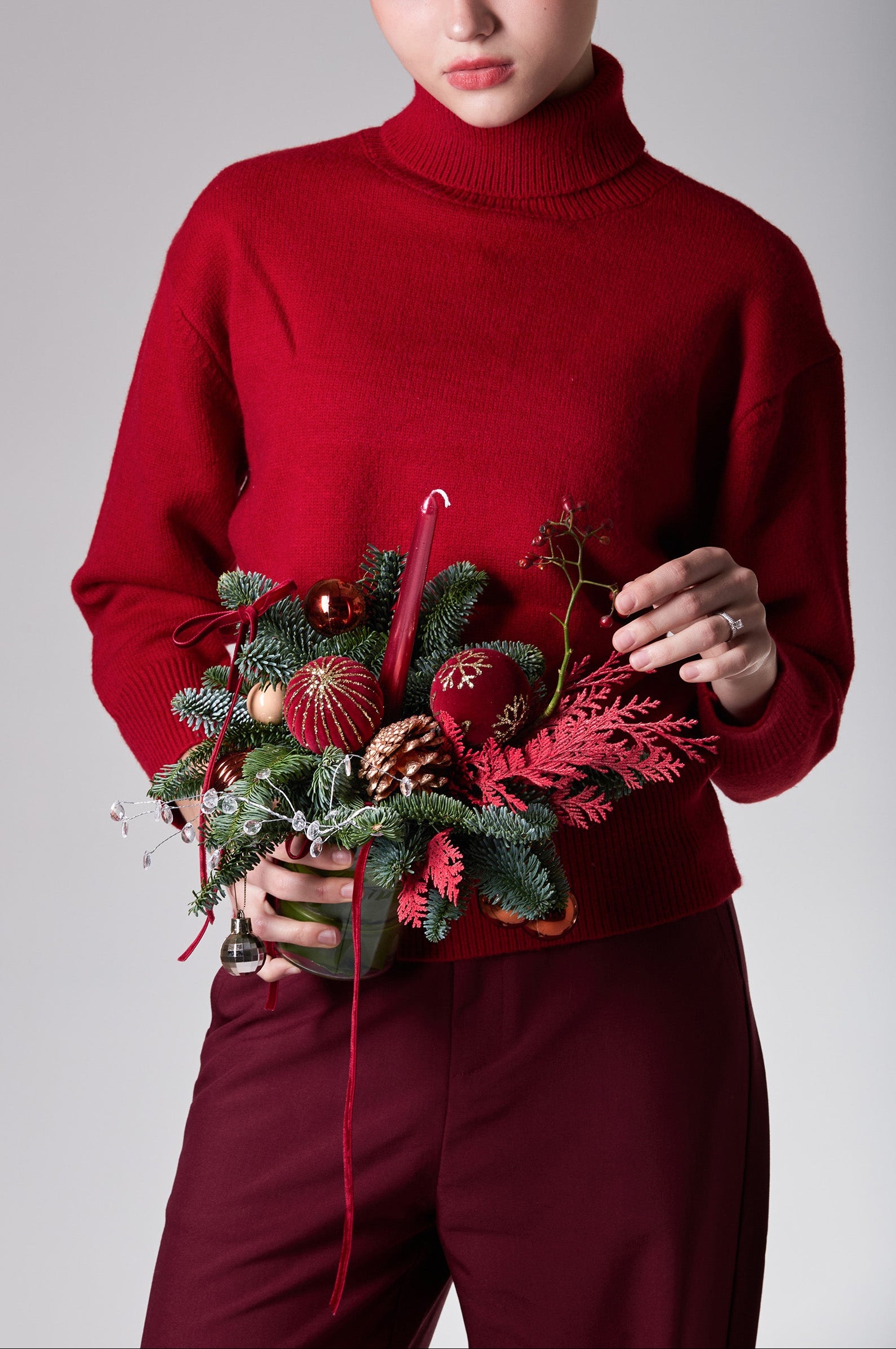 Crimson Petite is a refined mini Christmas arrangement featuring deep red ornaments, pine foliage and winter textures. Elegant styling for festive interiors.