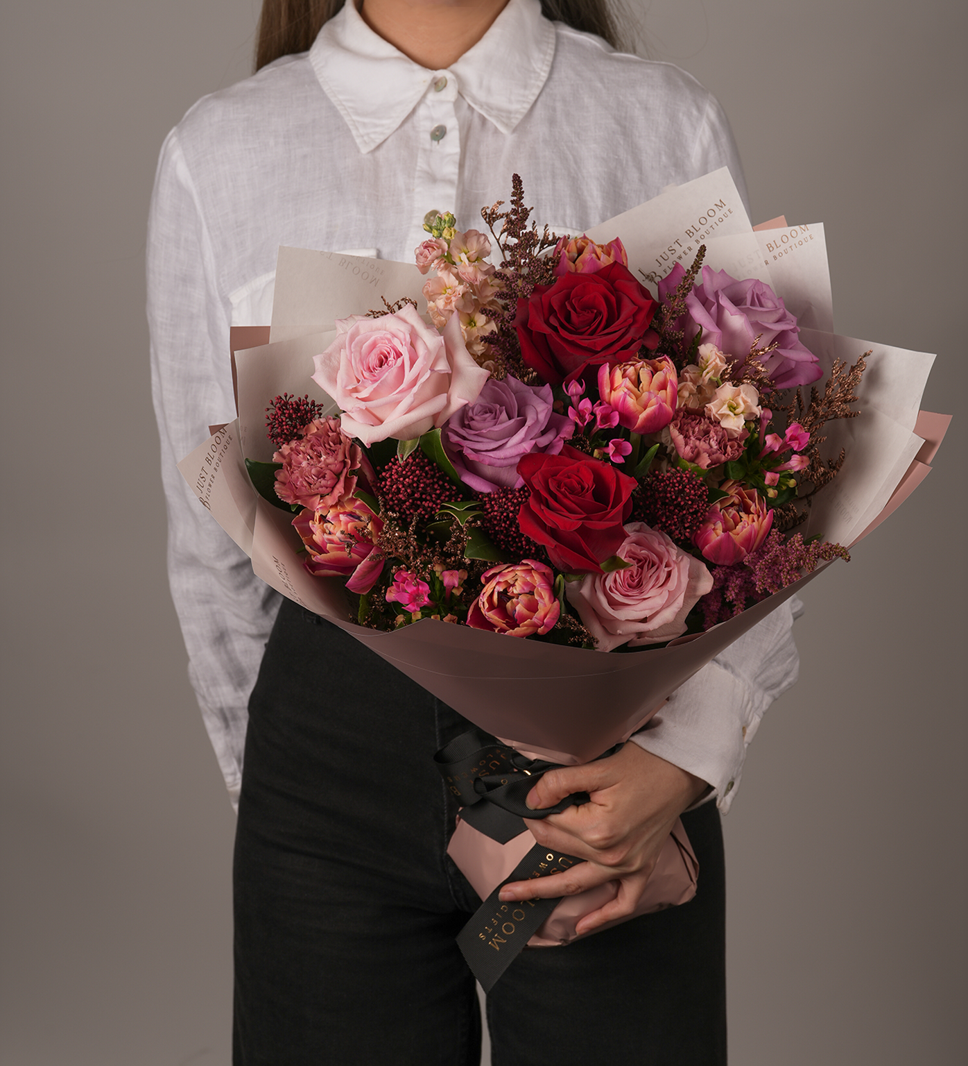 Dylan bouquet featuring blush, red, and lavender roses in mauve-toned wrapping – front view