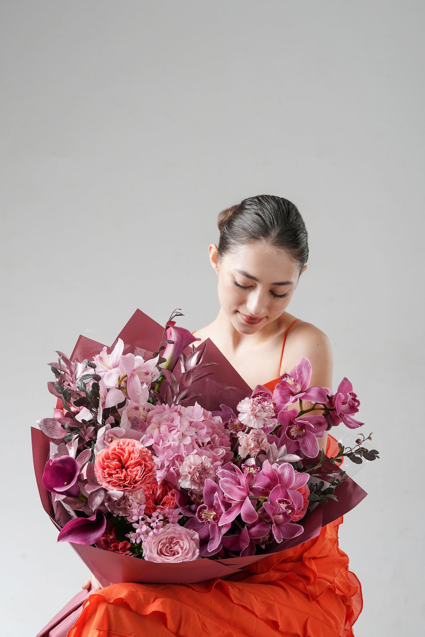 Contemporary bouquet with orchids and roses, wrapped in a luxurious and expressive style.
