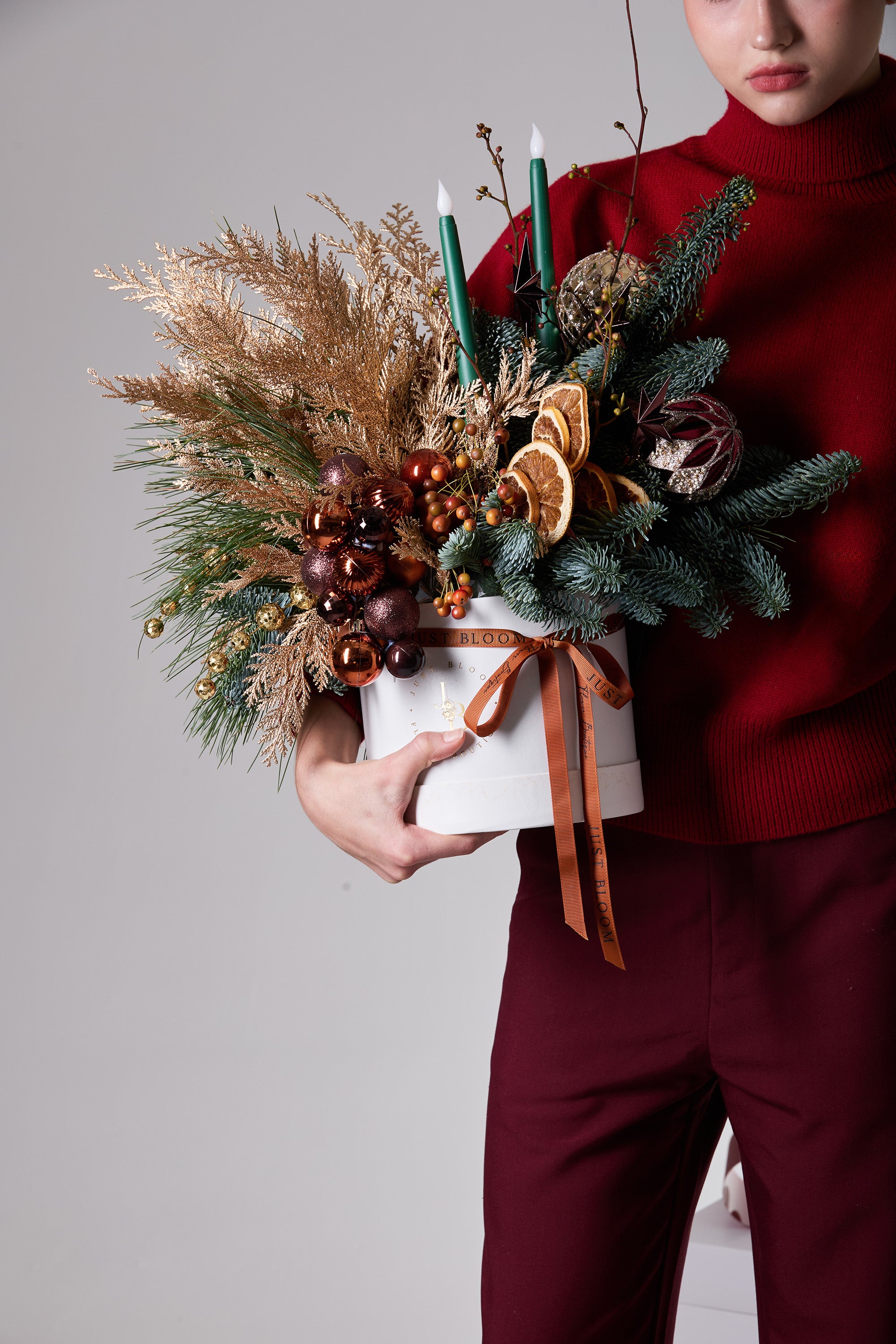 Ember Grove winter candle centerpiece with green taper candles and evergreen foliage