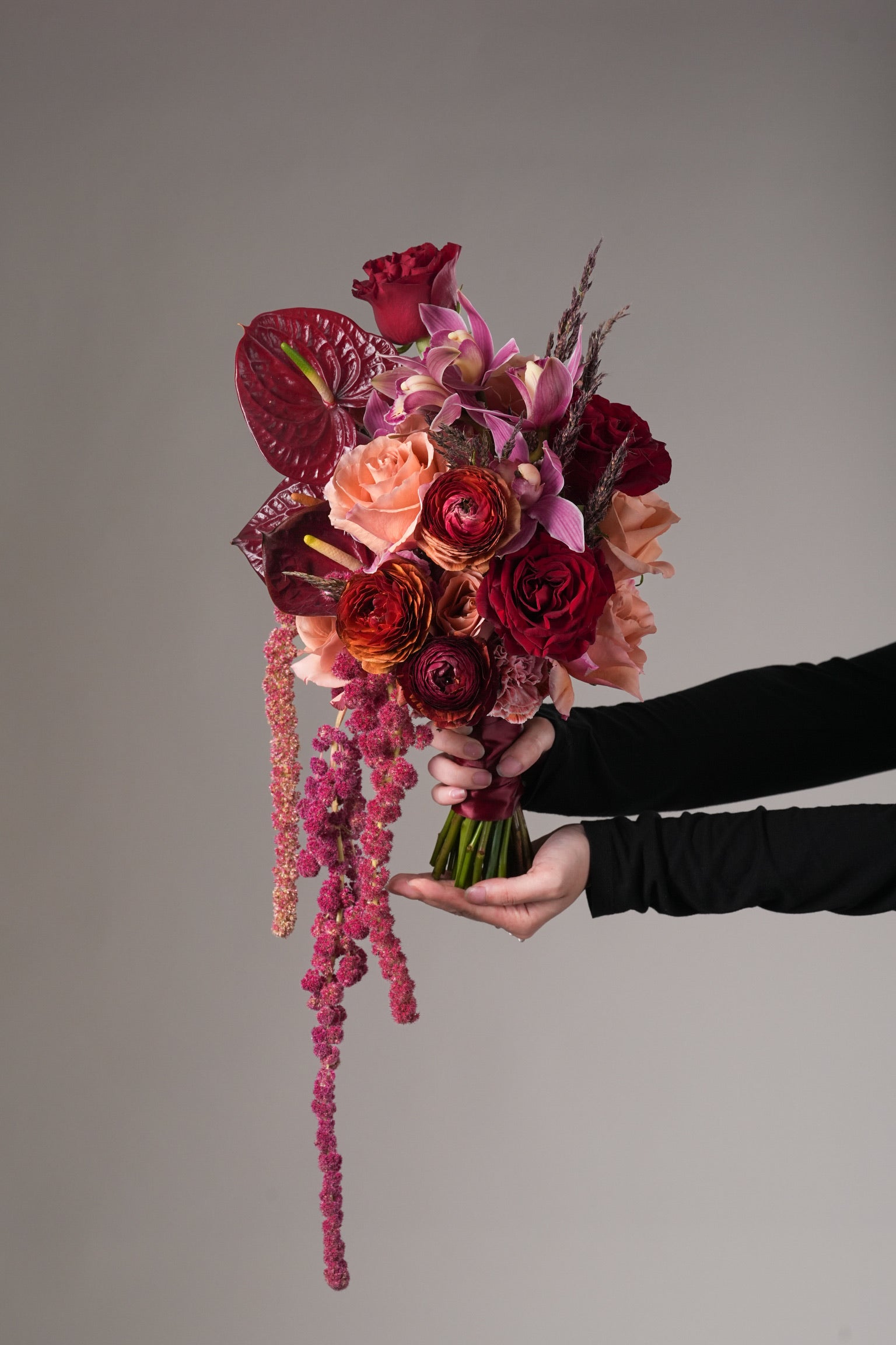 showing wedding-style arrangement with premium roses, orchids, and cascading florals for brides