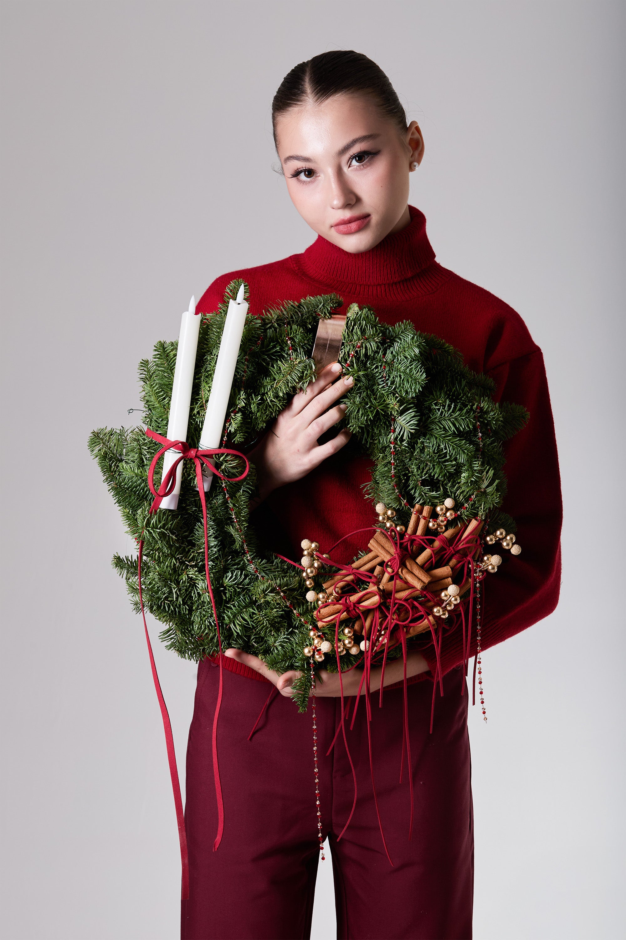 Glowing Emberwheel wreath with red berries, cinnamon clusters and candle accents