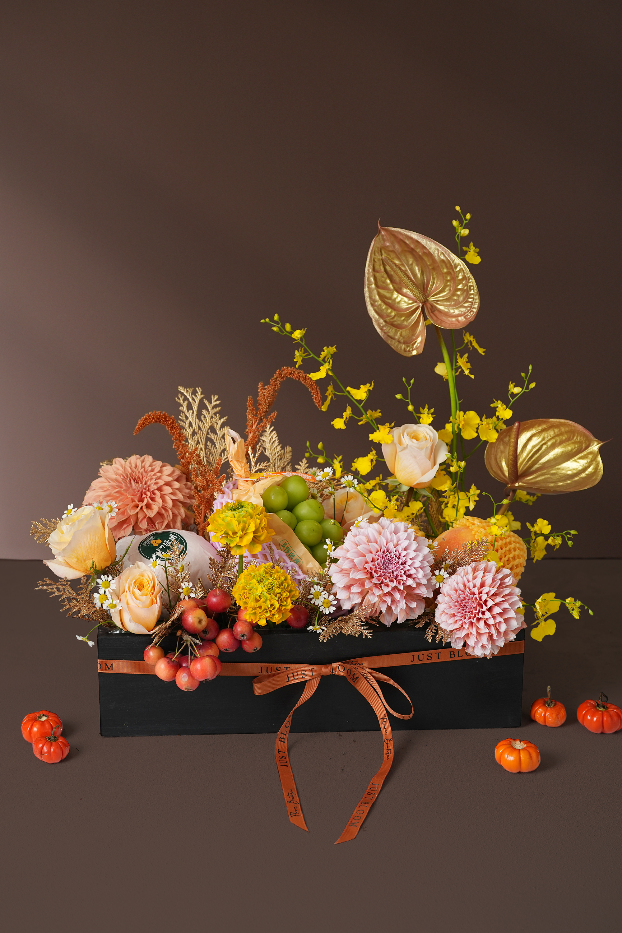 Golden Harvest Mid-Autumn gift box with golden anthuriums, dahlias, and fresh fruits including grapes and apples