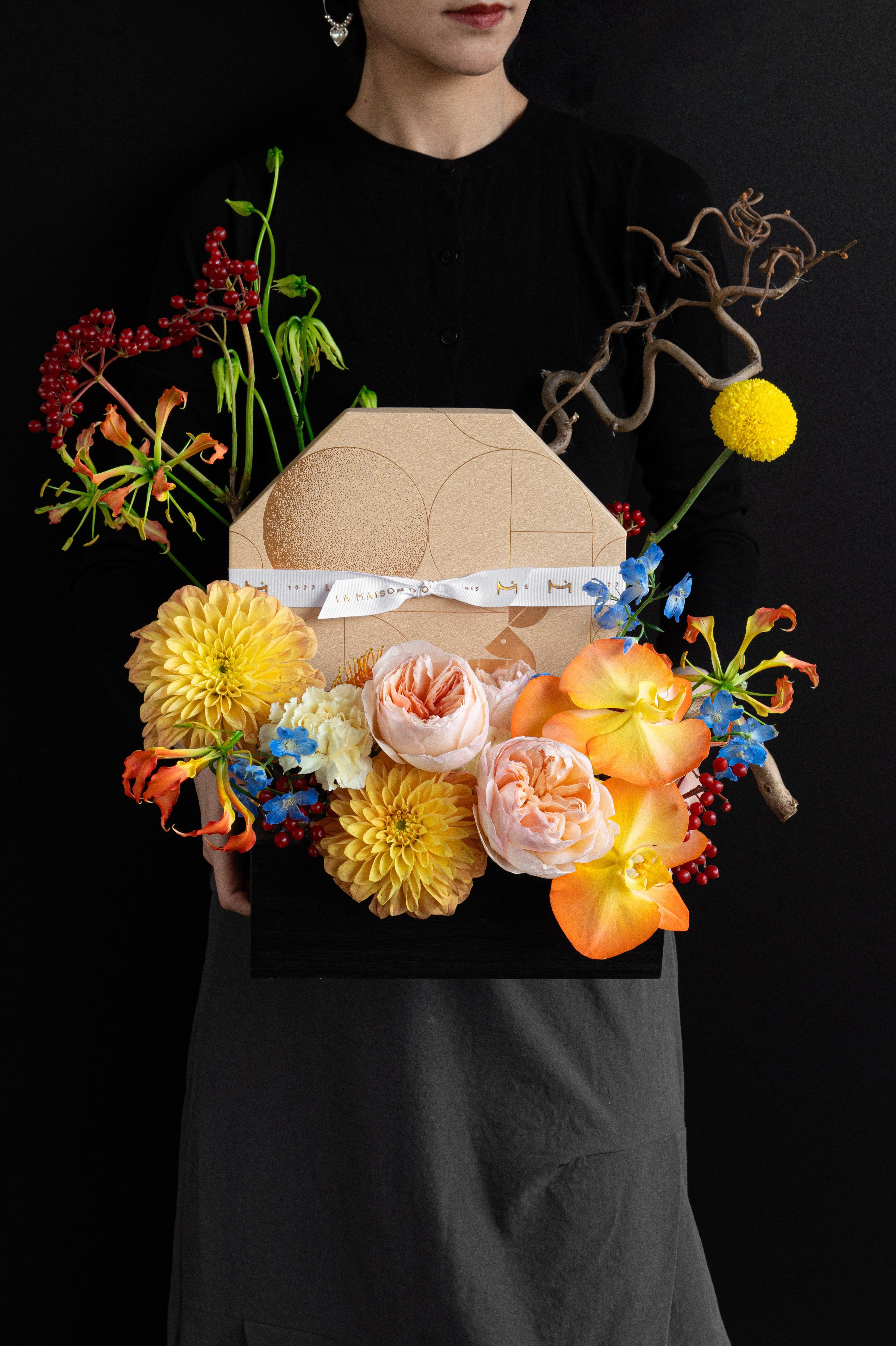 Model holding Just Bloom Autumn Reflection flower box with golden yellow and coral florals and chocolate gift box — Just Bloom Hong Kong