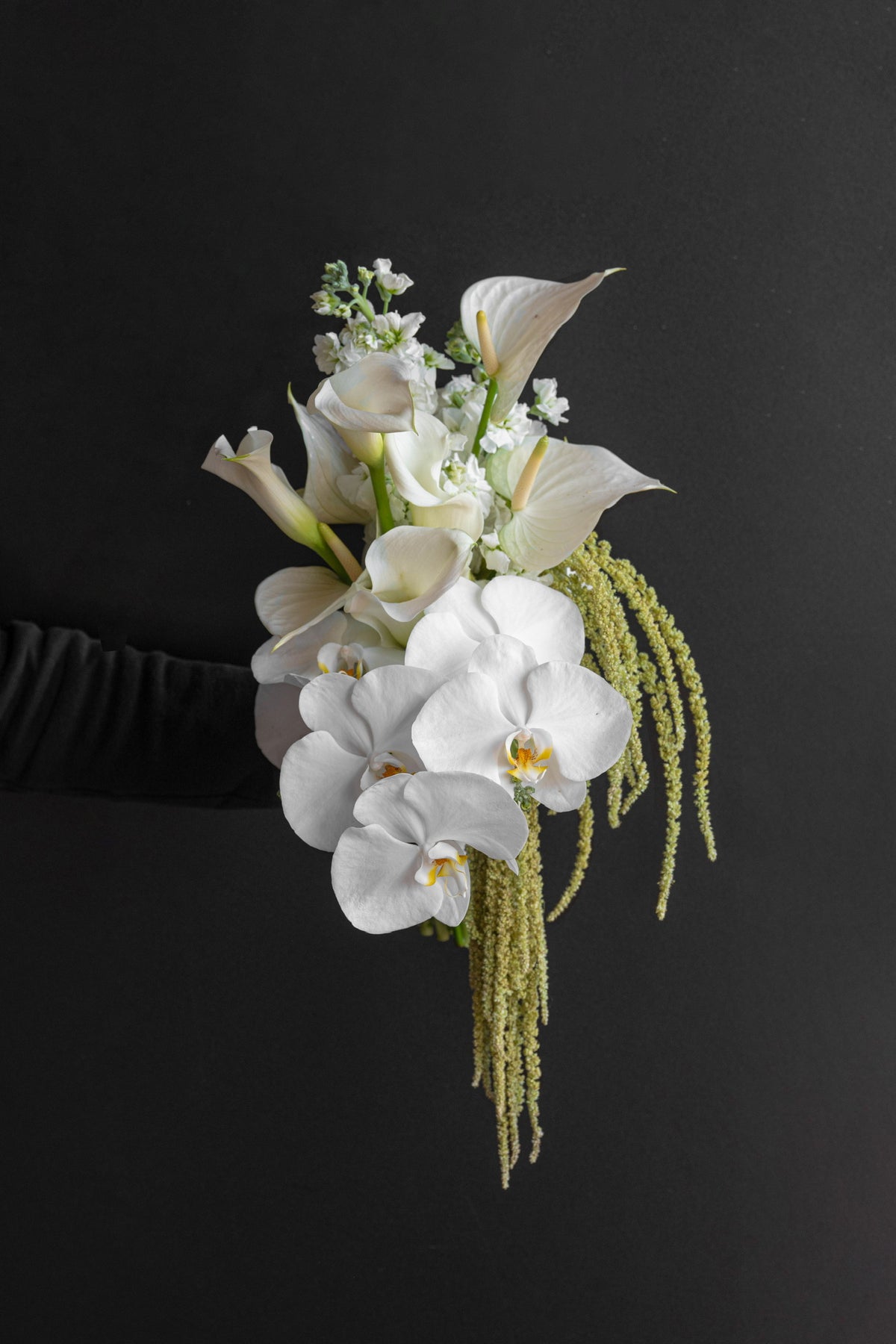 Model holding Now and Always bridal bouquet by Just Bloom Hong Kong, side profile view, showing the full cascading drop of trailing green against a dark background