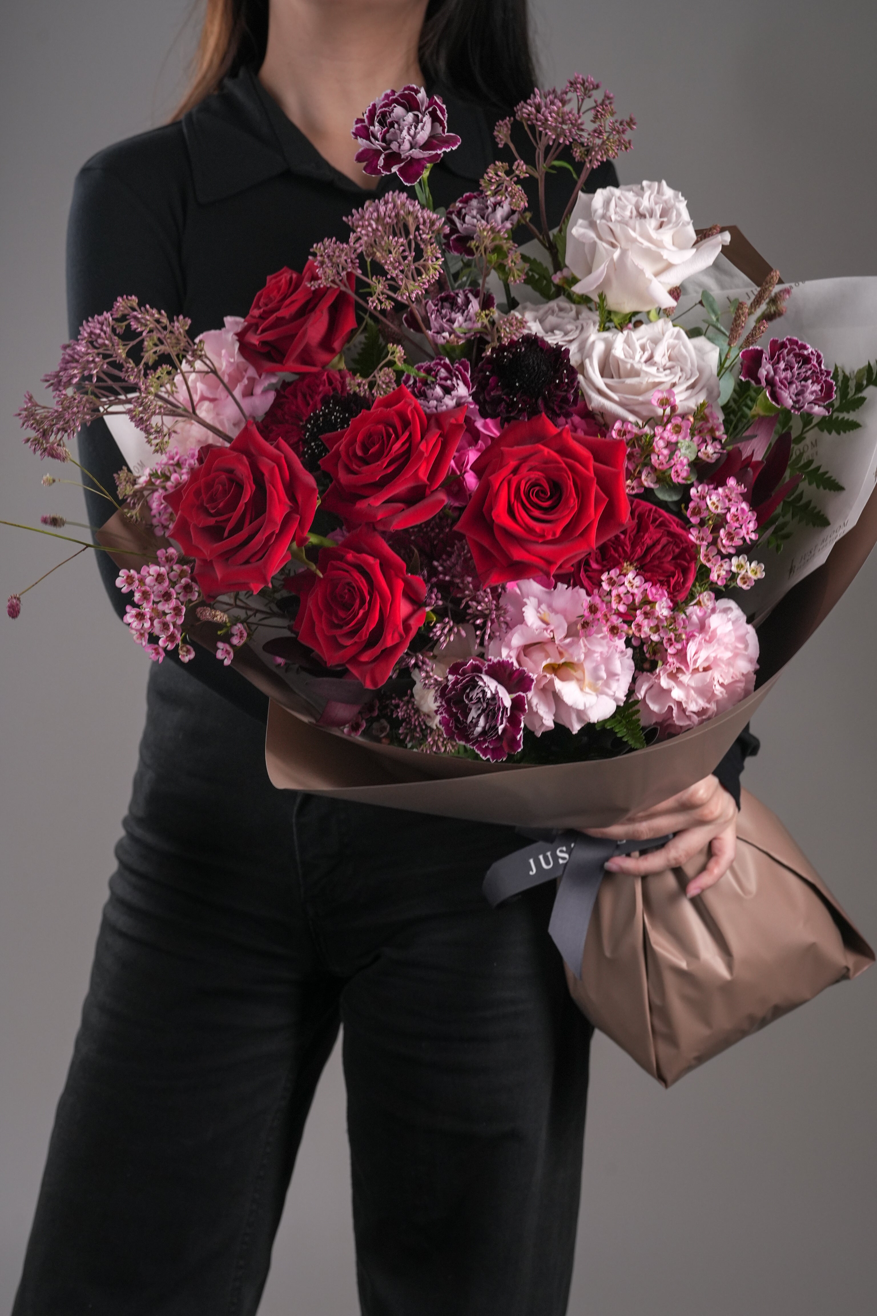 Just Bloom Hong Kong Arlene bouquet – model holding deep red and dusty pink hand-tied rose bouquet