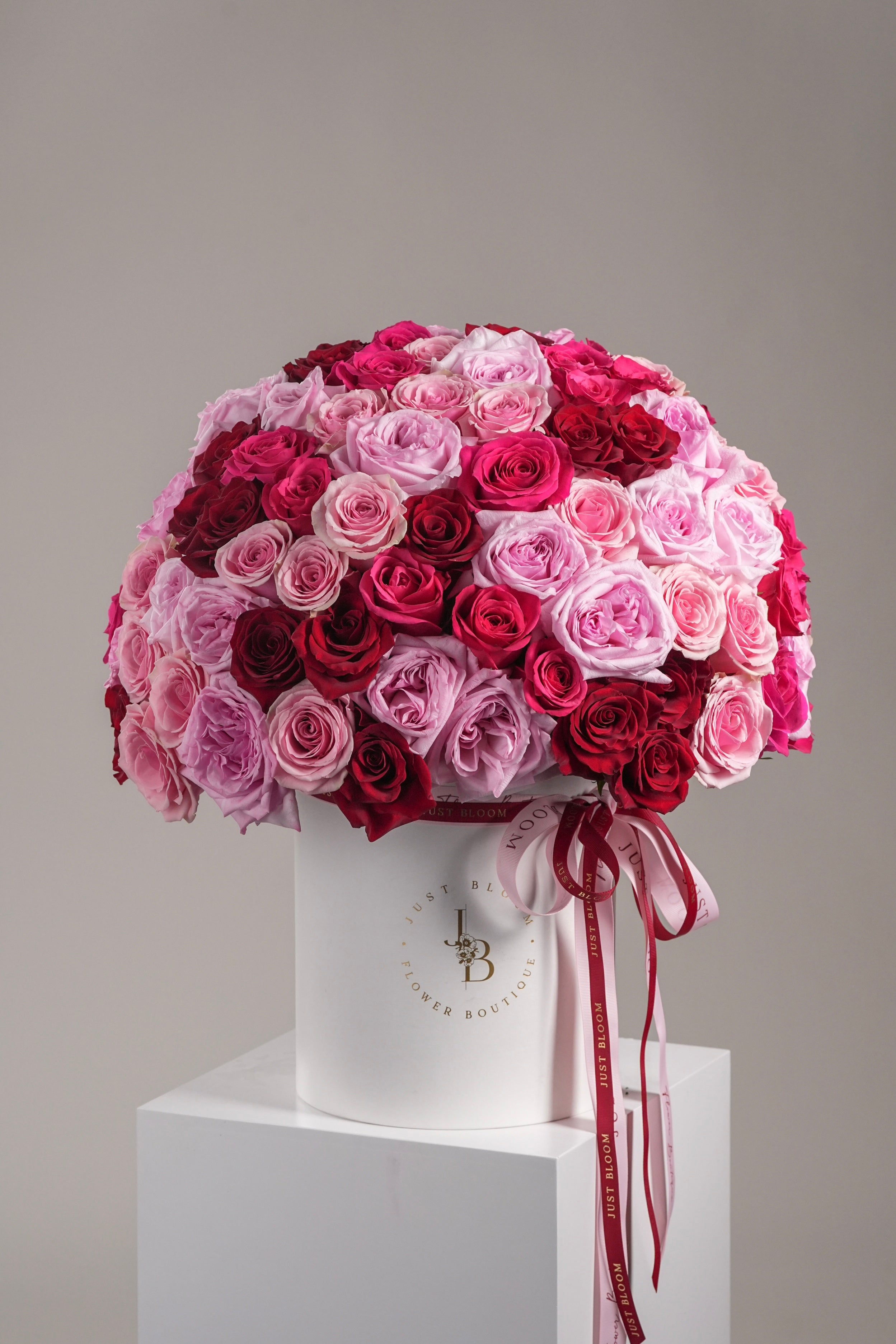 Close-up of Dora flower box with 99 red, pink, and hot pink roses in semi-spherical design