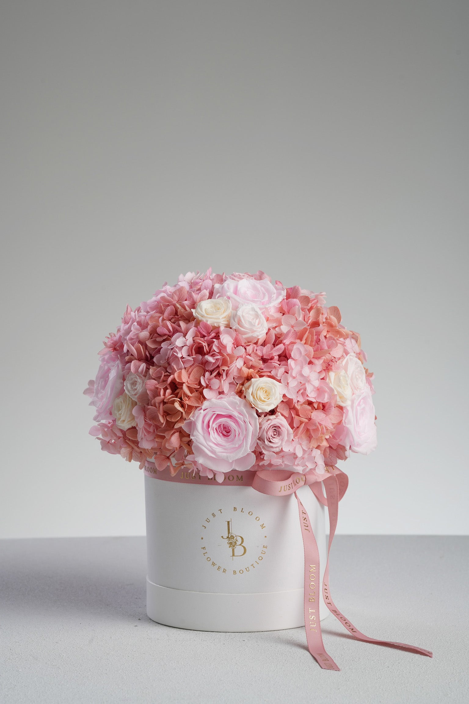 Kyra preserved flower arrangement in white hatbox showing pink roses and hydrangeas detail