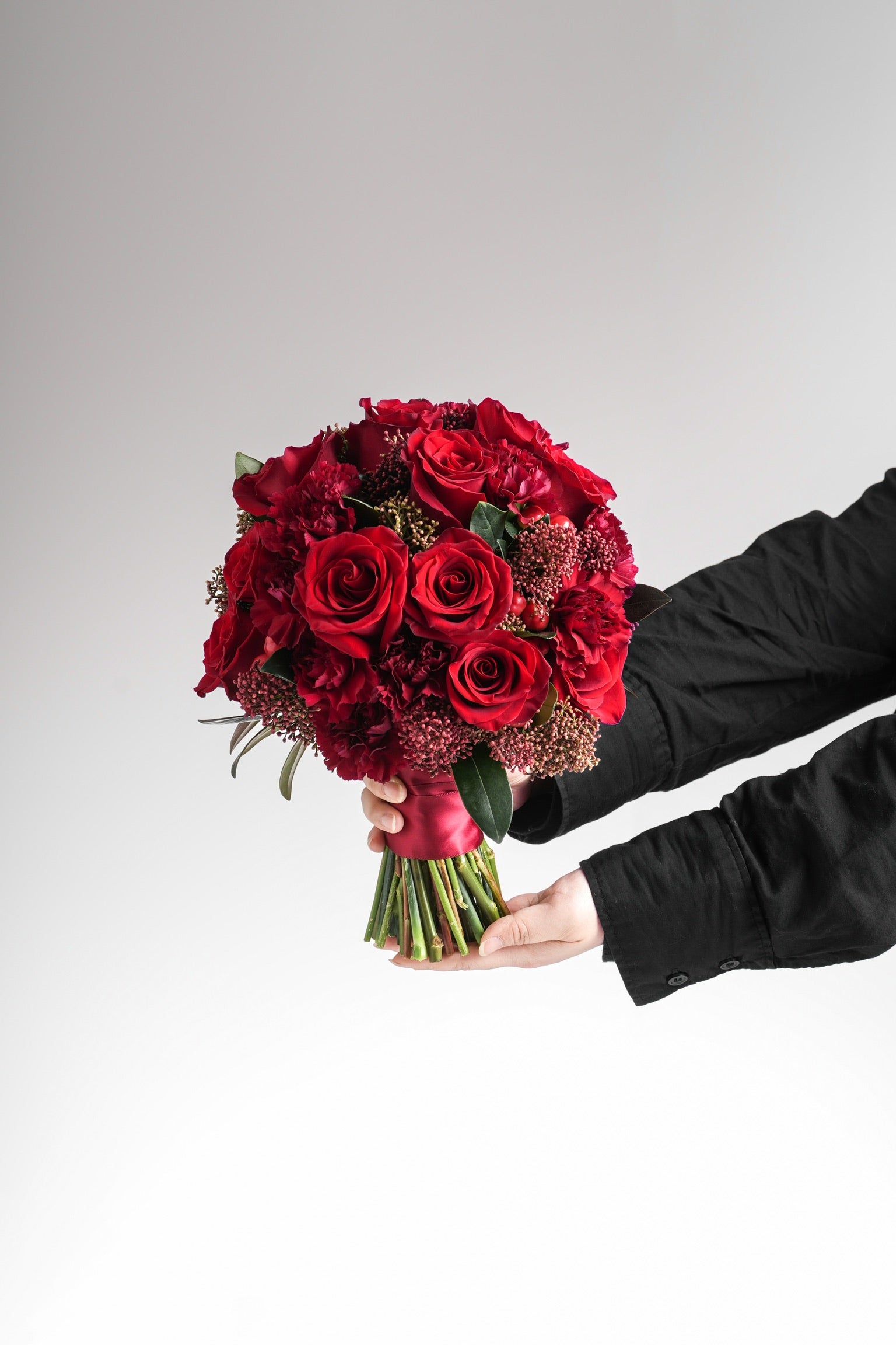 Liv - A bold and romantic red bridal bouquet featuring Ecuadorian roses, Dutch carnations, skimmia, hypericum berries, and lush greenery. Designed for brides seeking passion and elegance. Available for delivery in Hong Kong by Just Bloom.