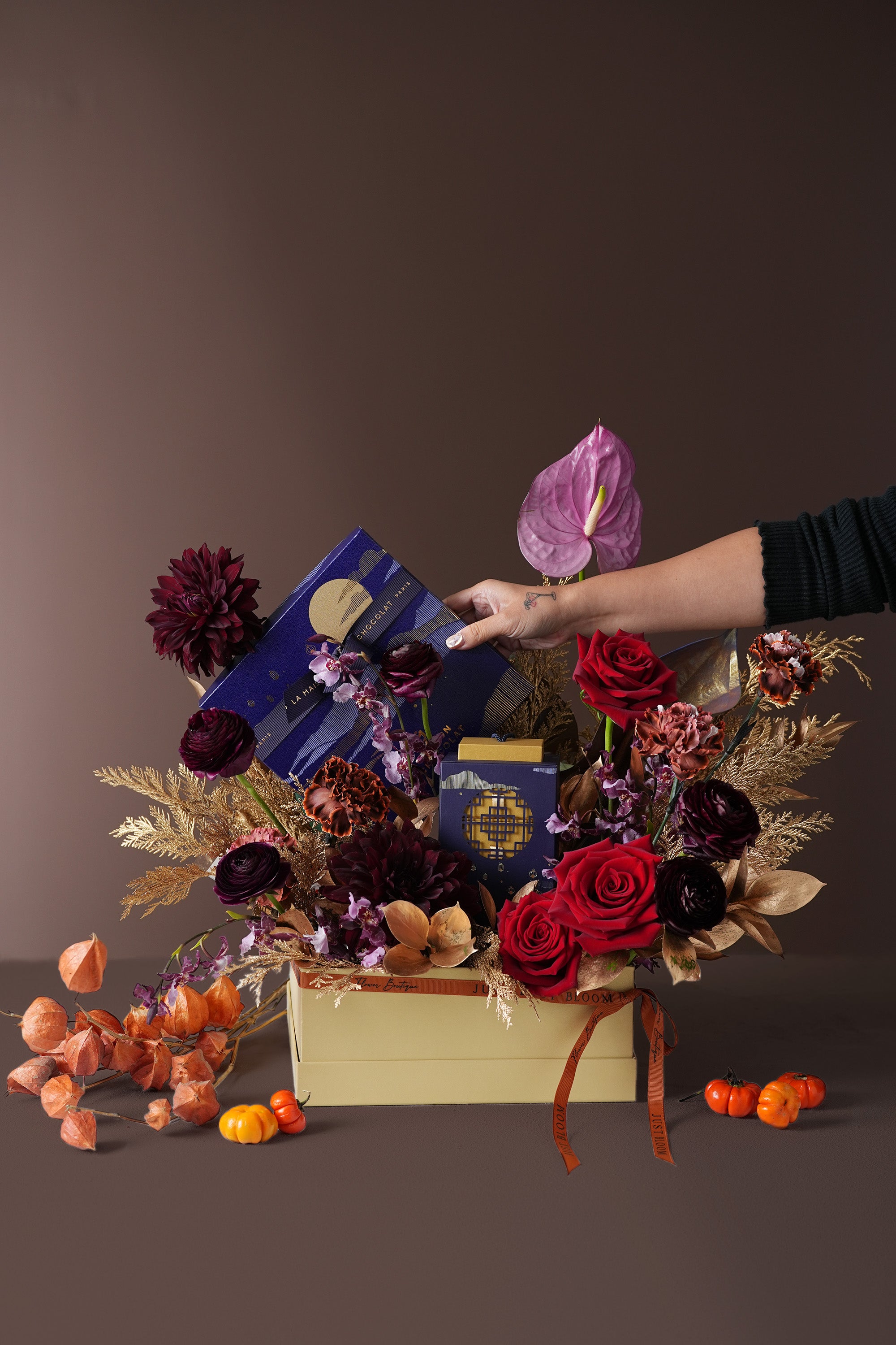 Lunar Elegance Mid-Autumn floral gift box held in hands, styled with rich flowers and chocolate box