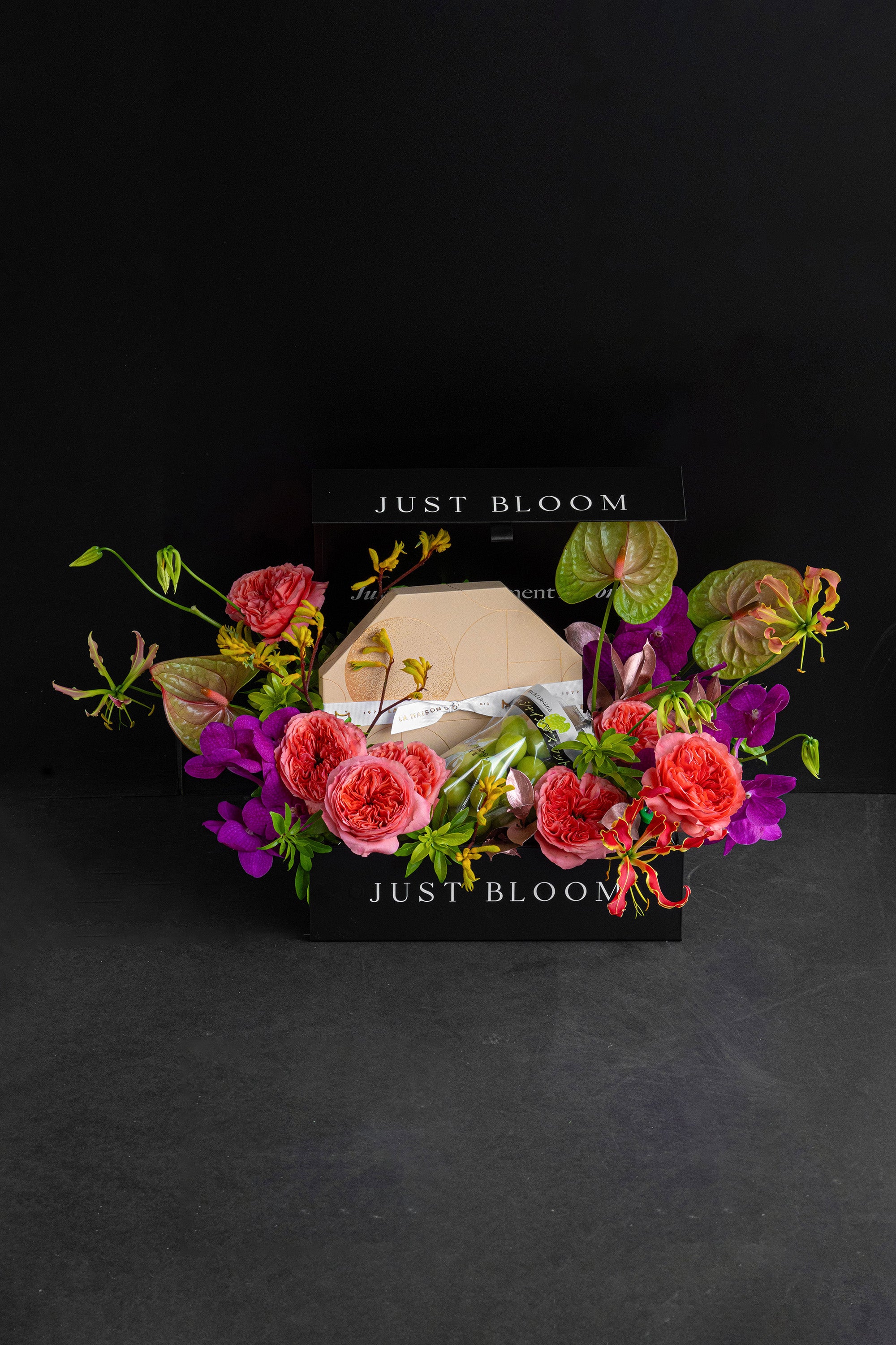 Just Bloom Moonlit Treasure flower box with coral pink and violet florals against a black background — Just Bloom Hong Kong