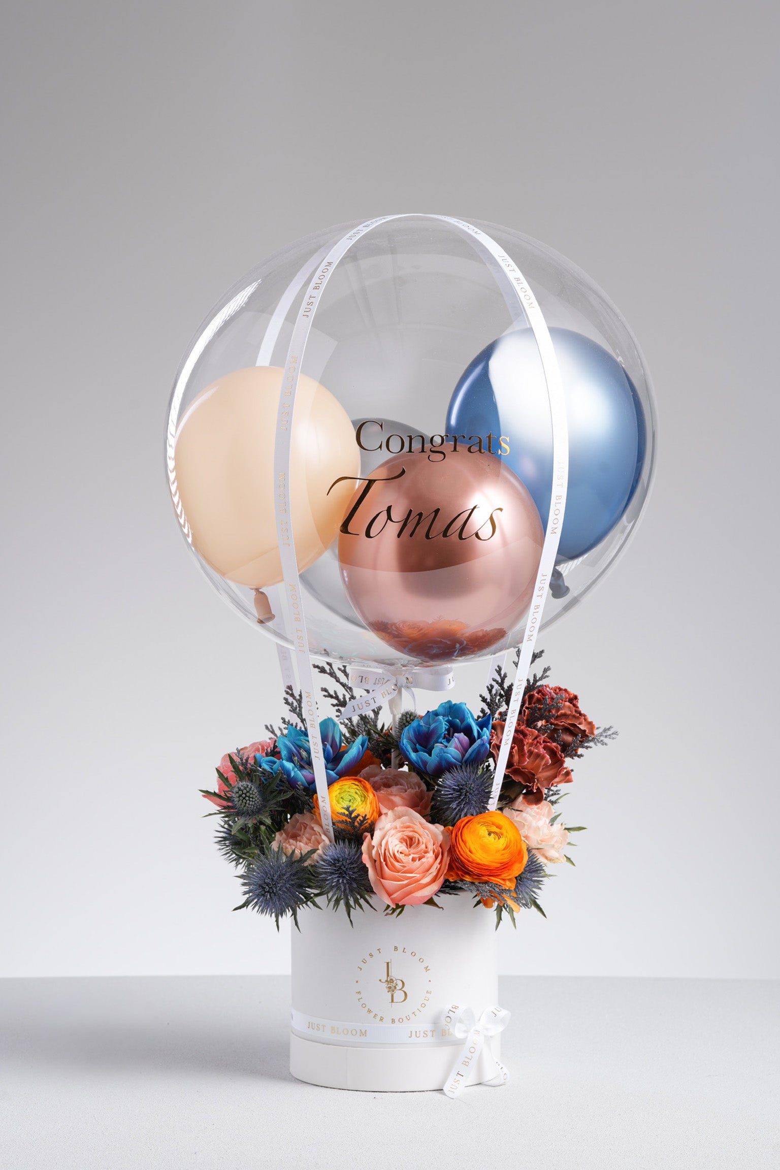 Opal - A bold and modern floral arrangement featuring dyed tulips, peach roses, ranunculus, eryngium, carnations, and rich fillers in vivid blue, orange, and peach tones. Available for same-day delivery in Hong Kong by Just Bloom.