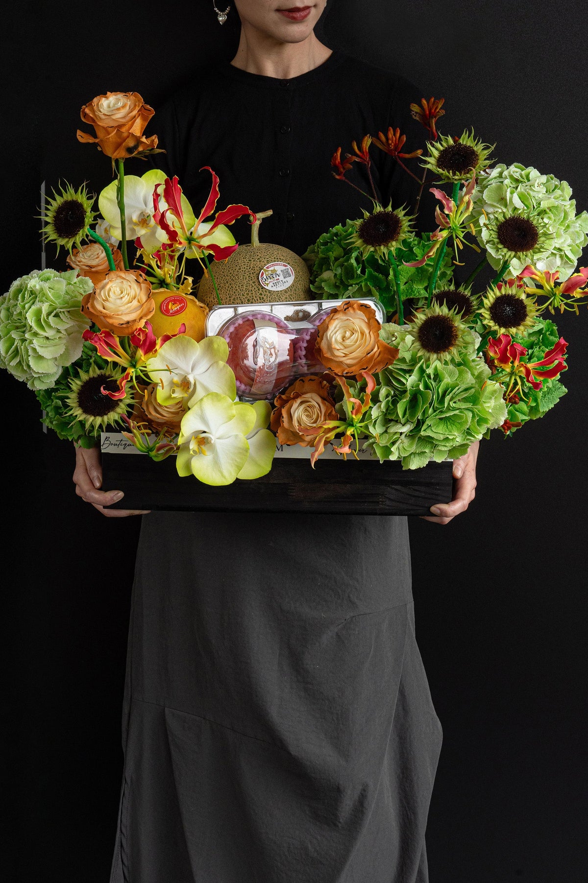 Model holding Just Bloom Orchard Ode flower box with green hydrangeas, sunflowers and seasonal fruit — Just Bloom Hong Kong