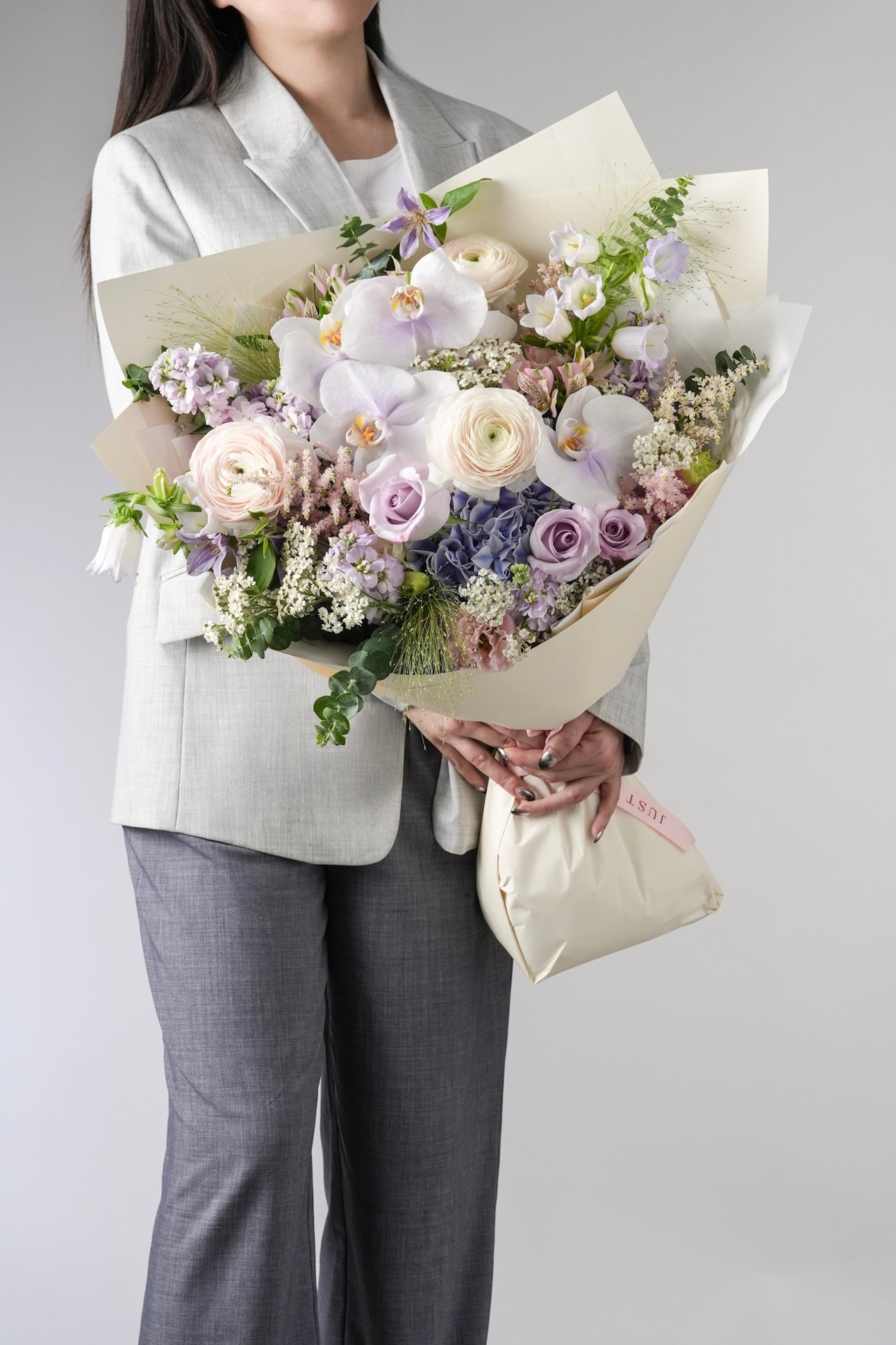 Sandra bouquet with pastel purple orchids, roses, ranunculus, hydrangeas and greenery
