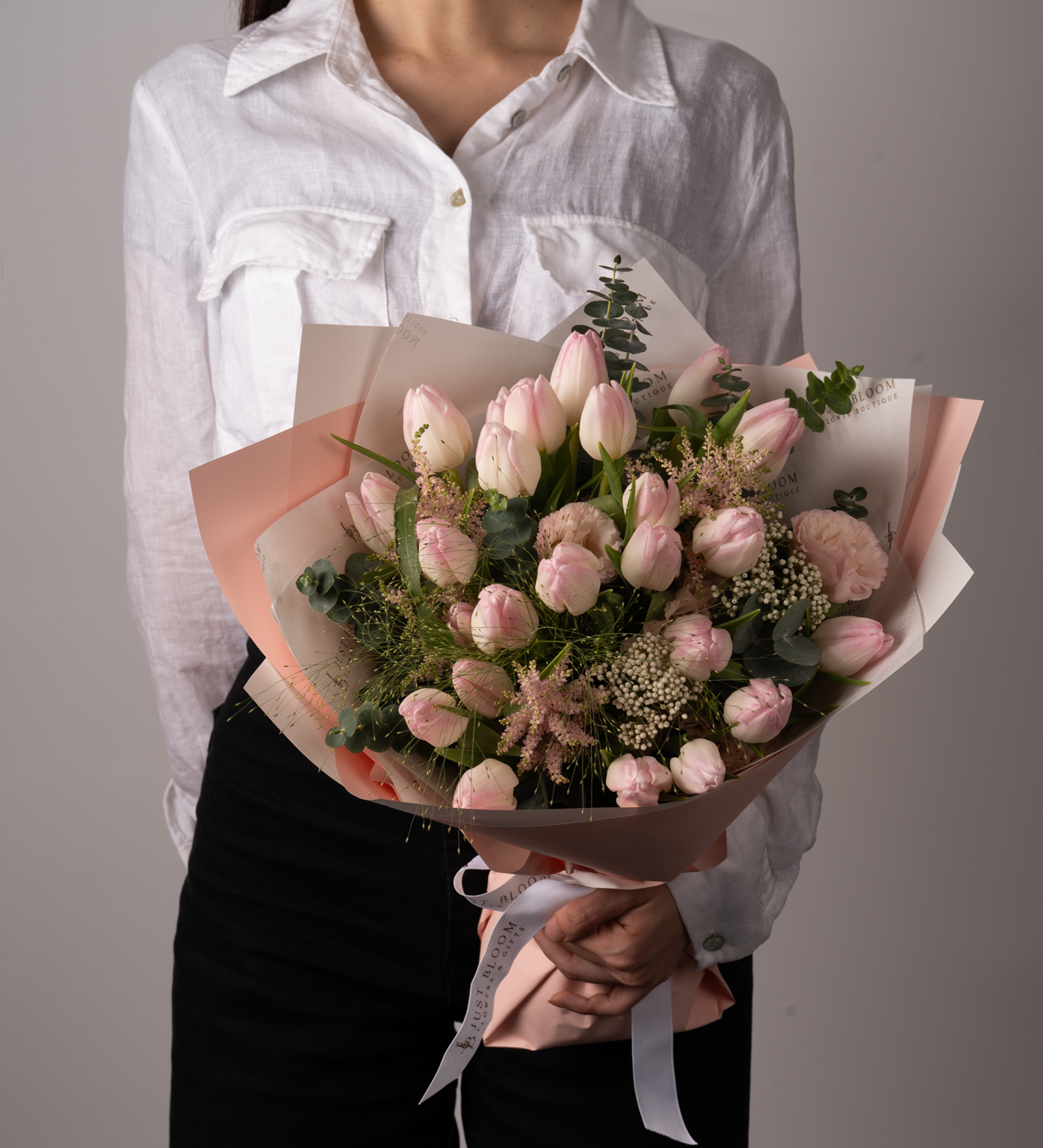 Selah bouquet with soft pink tulips, astilbes, rice flowers, eucalyptus, and frosted explosion greenery