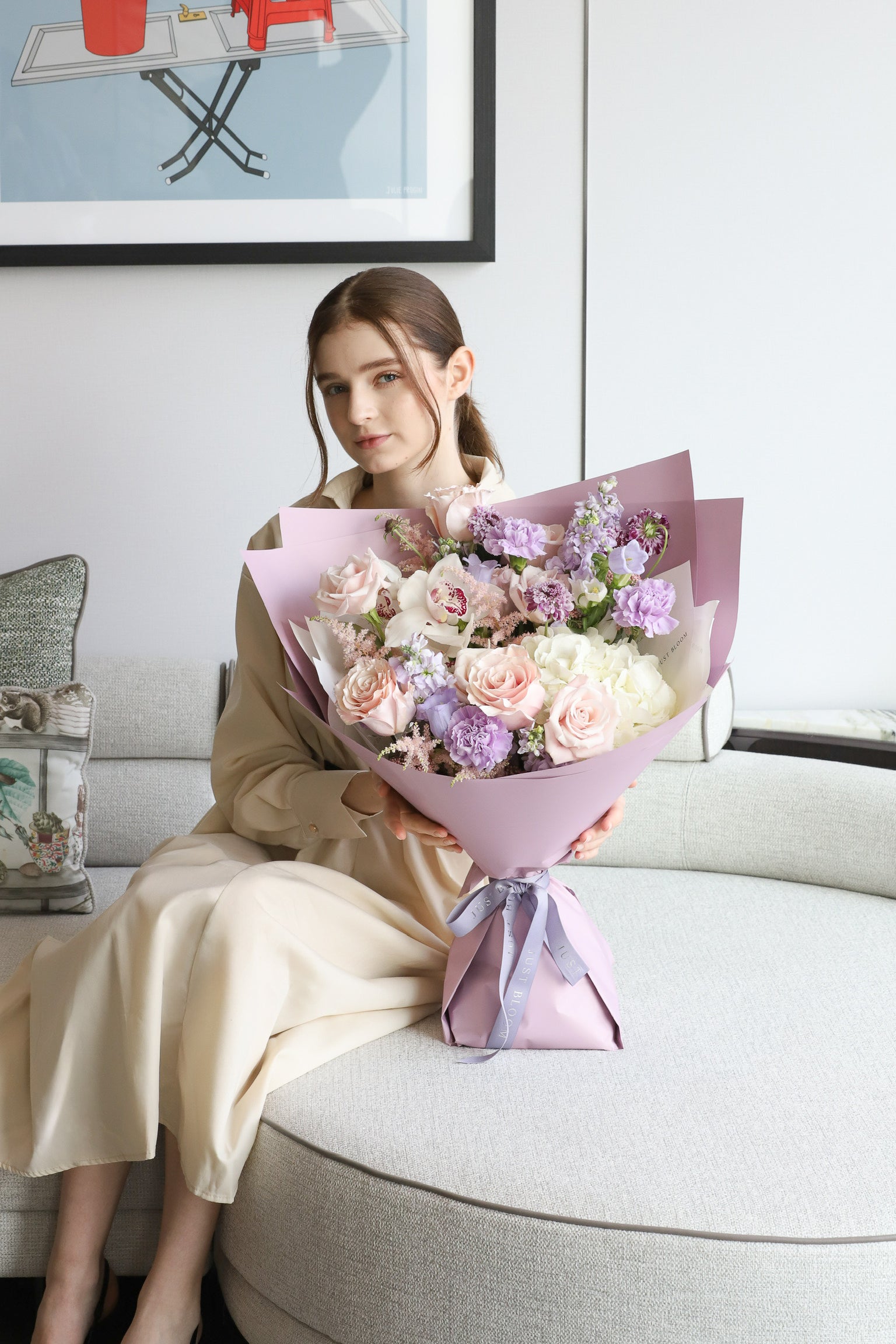 A model holding Soft & Timeless luxury bouquet by Just Bloom Hong Kong, showcasing soft blush roses, lavender blooms and ivory florals in dusty mauve wrapping