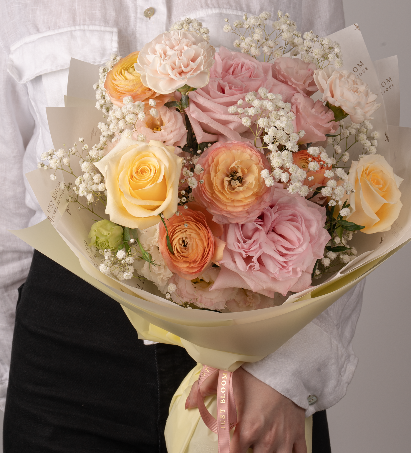 Stevie bouquet showcasing Ecuadorian roses and Dutch ranunculus in joyful warm tones