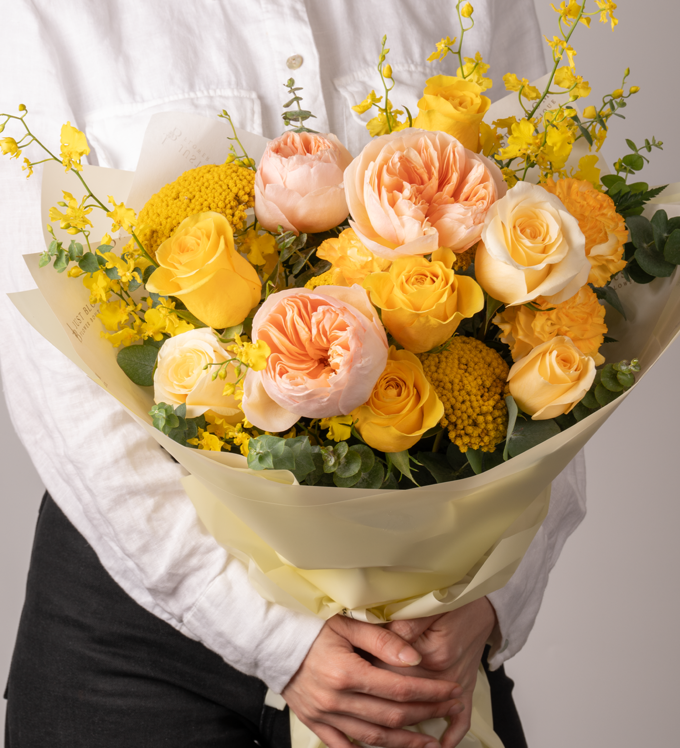 Close-up of Amanda floral bouquet featuring yellow and peach tones with fillers