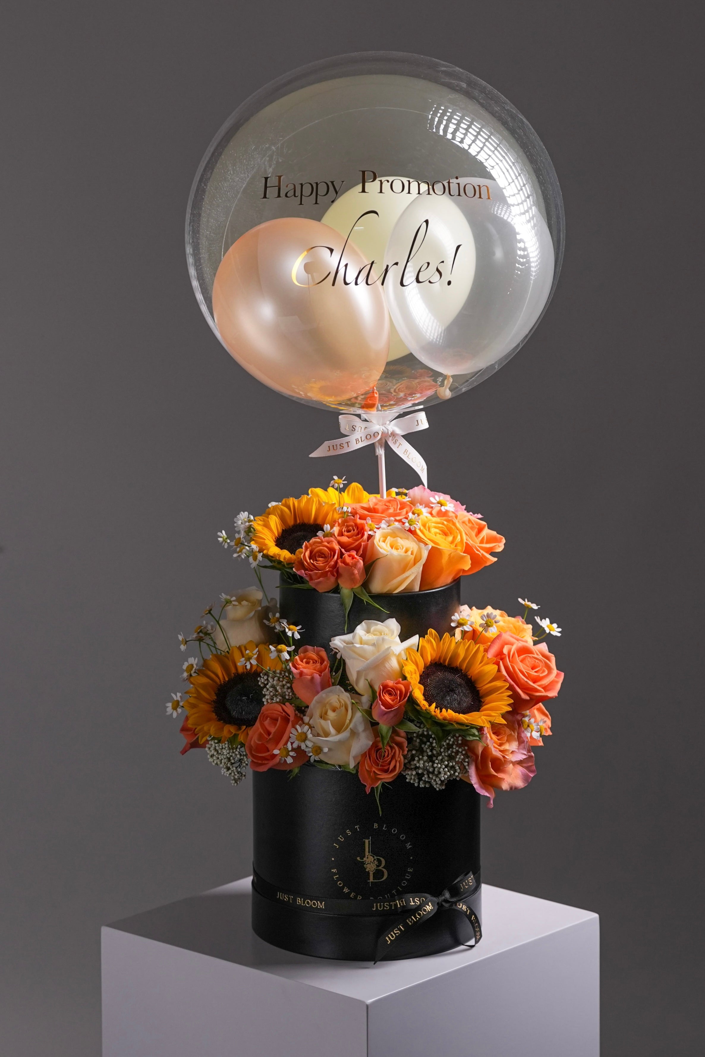 Sunny flower box with sunflowers, Ecuadorian roses, and orange Dutch blooms in a black hatbox with balloon topper