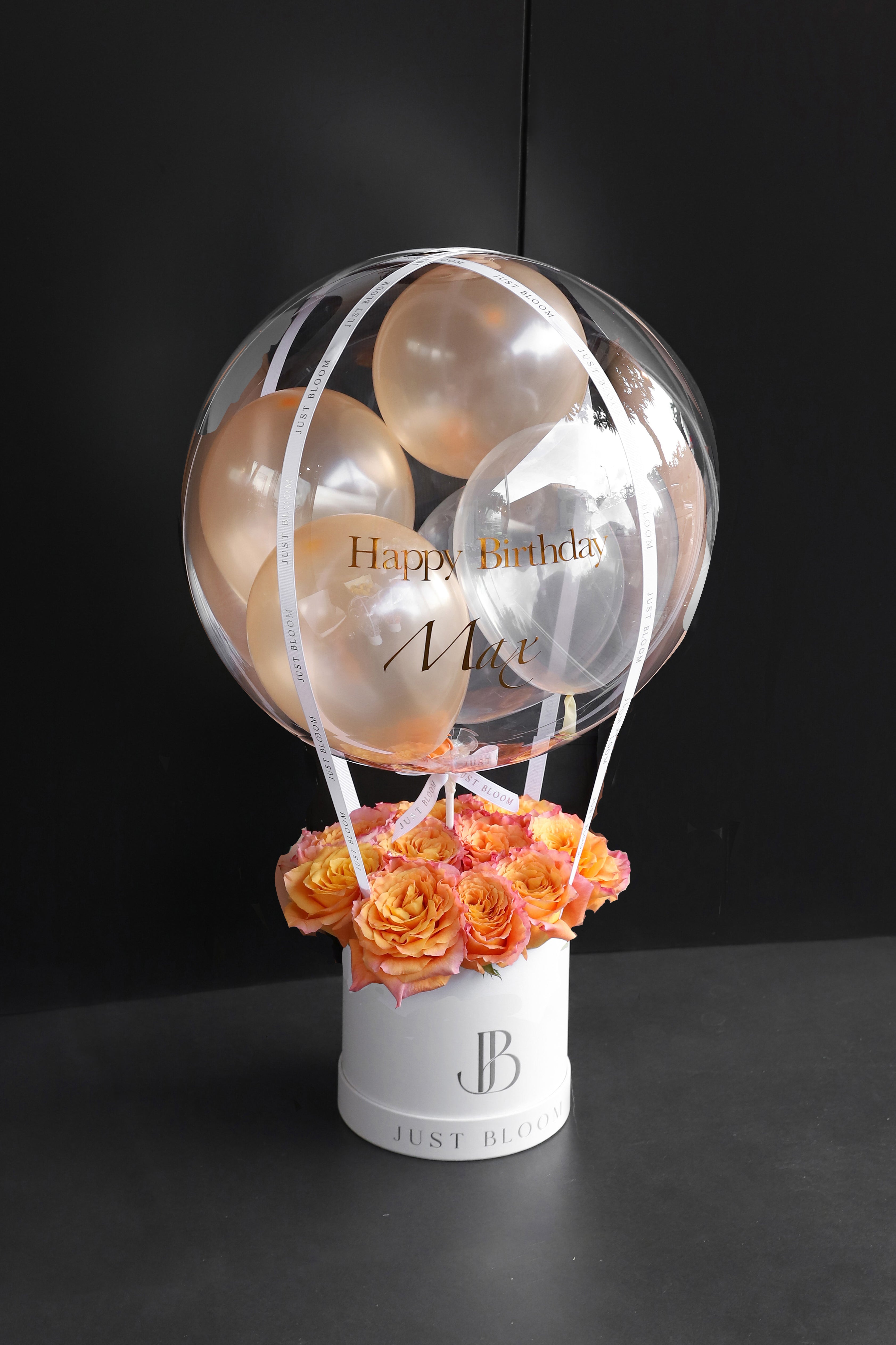 All-orange and peach rose balloon flower box with a large crystal balloon containing champagne and clear balloons in a white Just Bloom round box against a dark background — Just Bloom Hong Kong