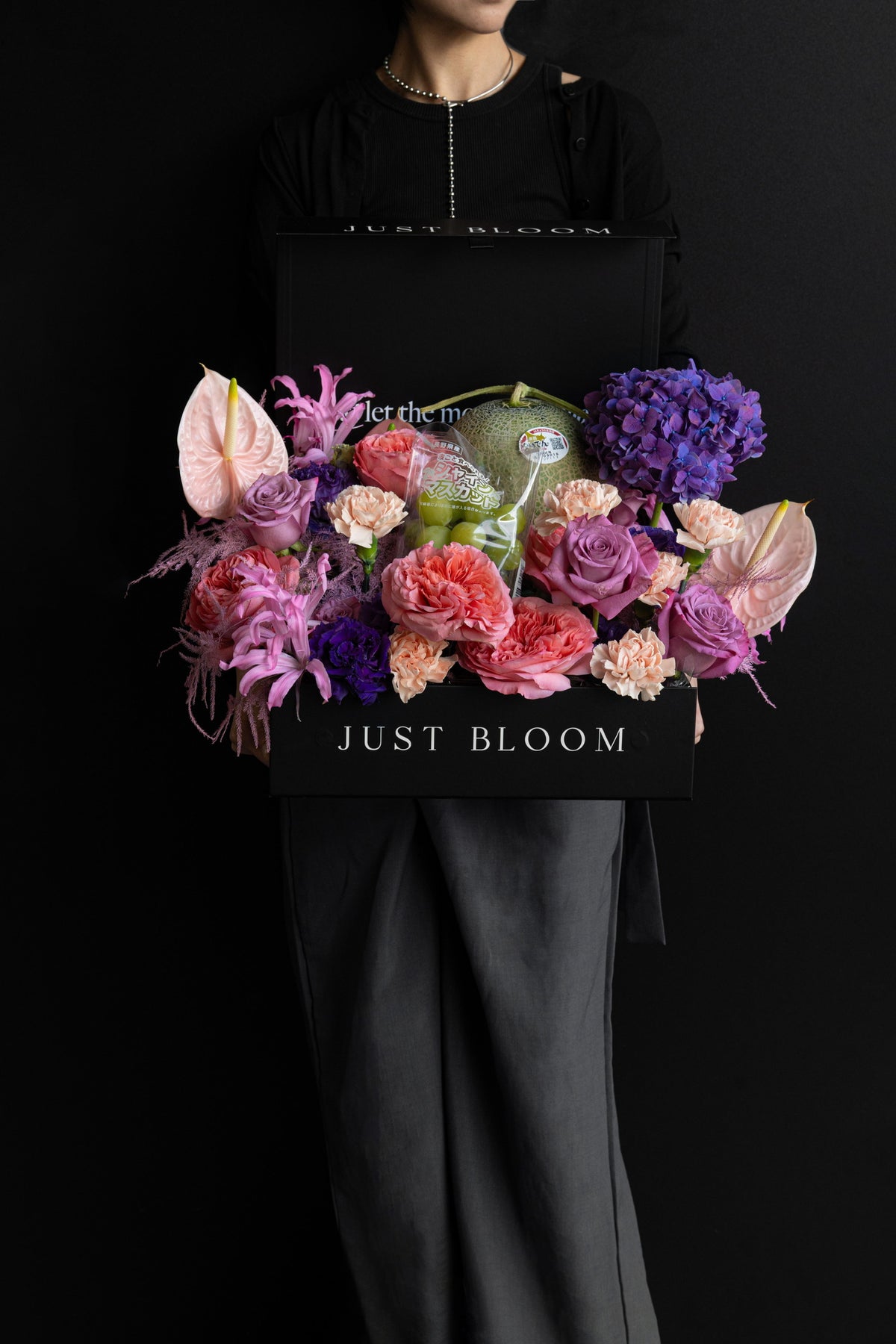 Close-up detail of Blush Altar florals: Anthurium, Garden Rose, and feathery dried pink elements in a deep-tone luxury presentation
