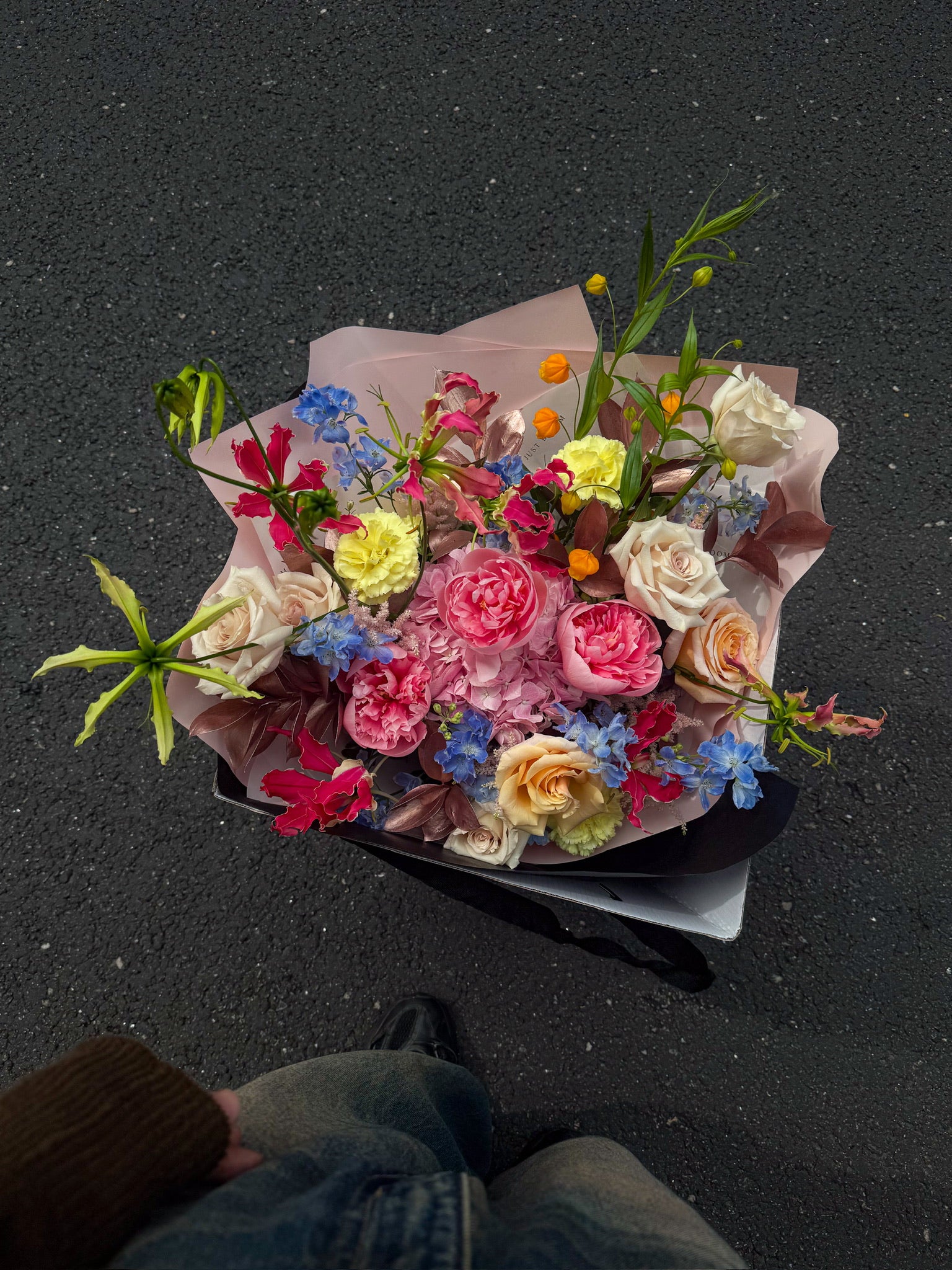 Wild Bunch luxury bouquet by Just Bloom Hong Kong photographed from above, showcasing an abundant mix of peonies, roses, carnations, delphiniums, flame lilies and chinese lantern lilies in blush and white wrapping
