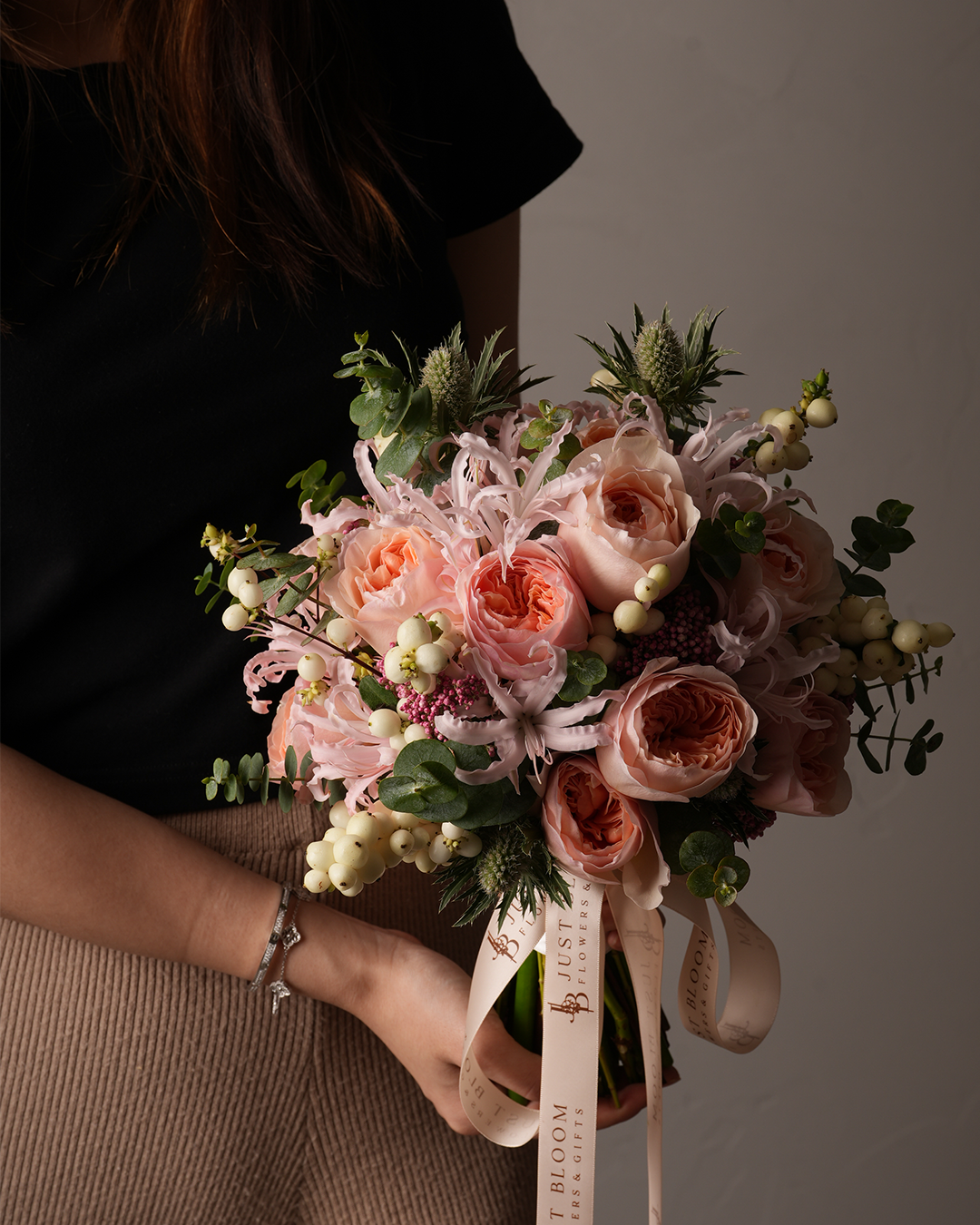 Sloane peach bridal bouquet with Juliet roses, snowberries, and greenery