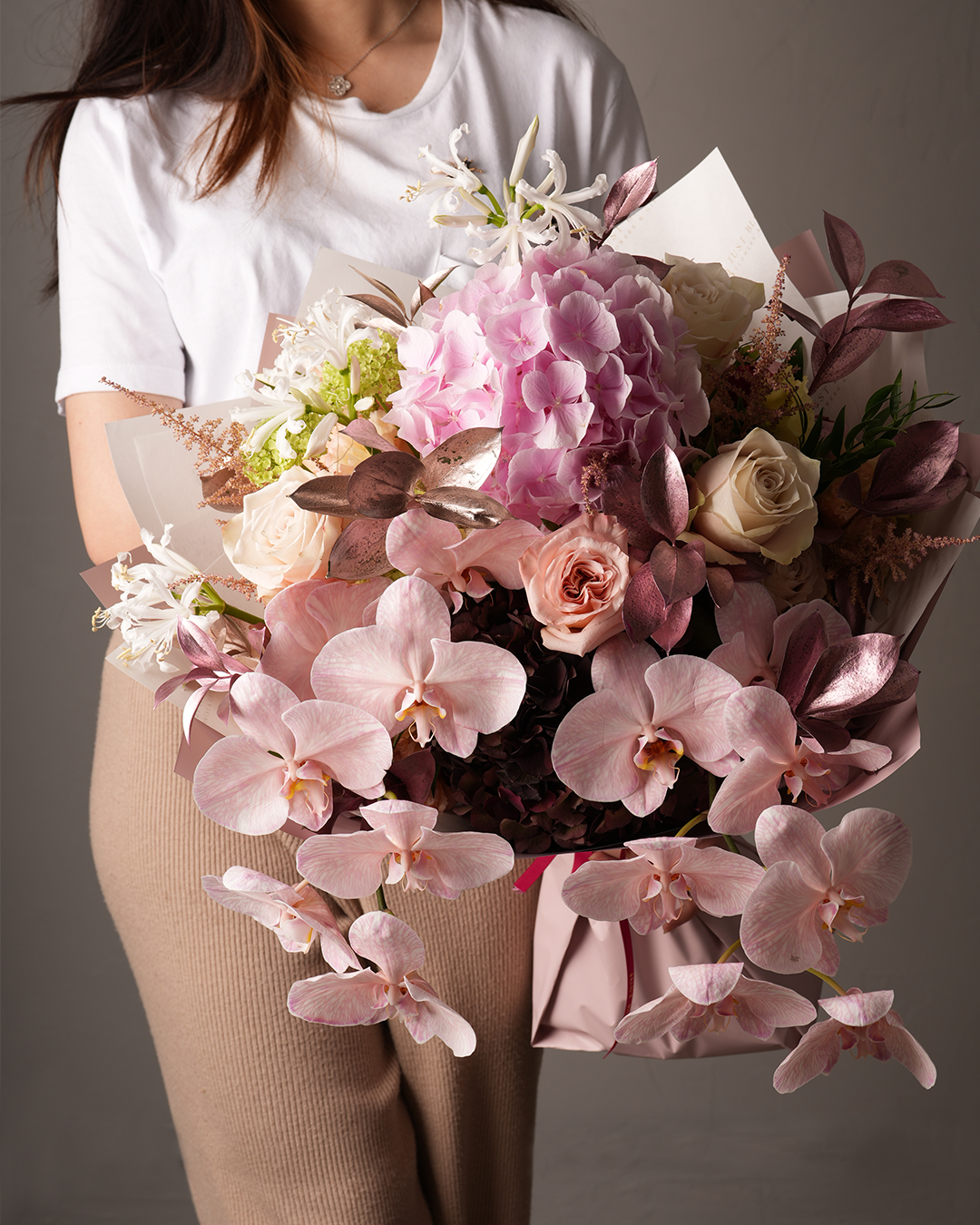 Woman holding Georgia blush orchid and rose bouquet – Just Bloom HK luxury floral gift