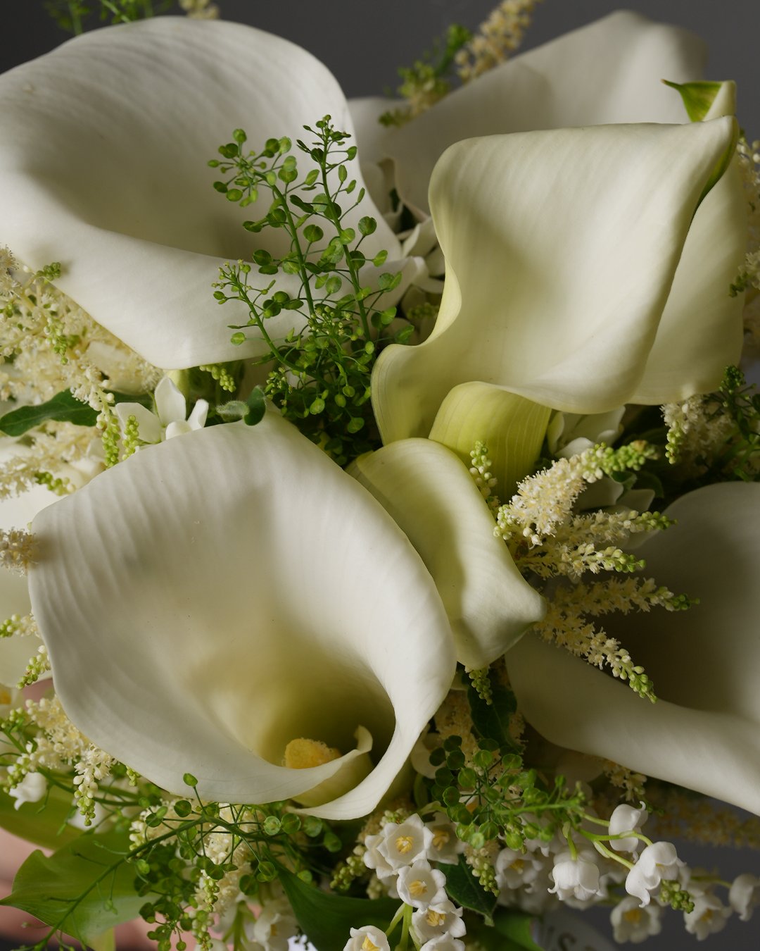 Close-up of Finley bouquet featuring Dutch calla lilies and lily of the valley by Just Bloom