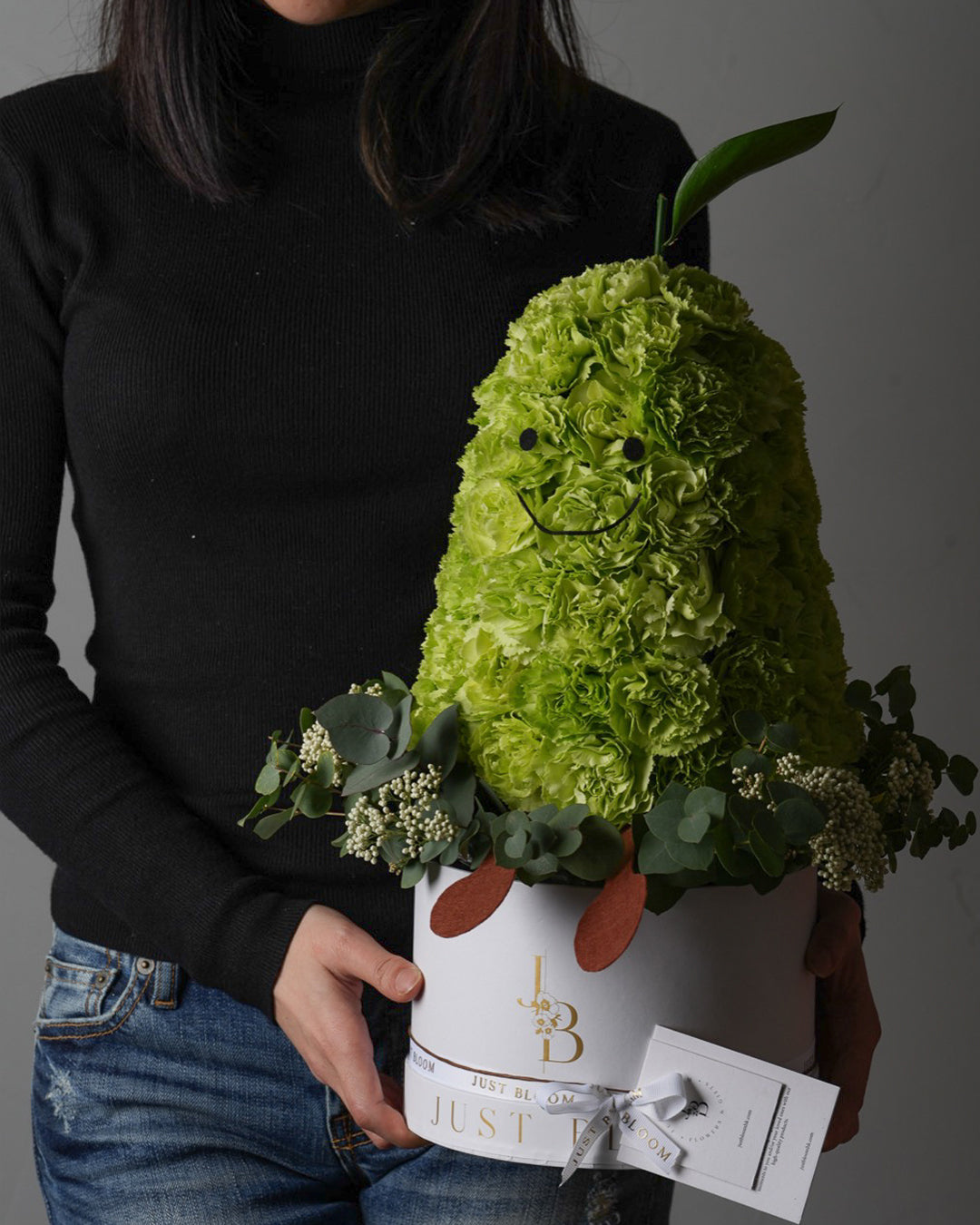 Close-up view of Little Pear showing green carnations arranged in pear shape with decorative elements