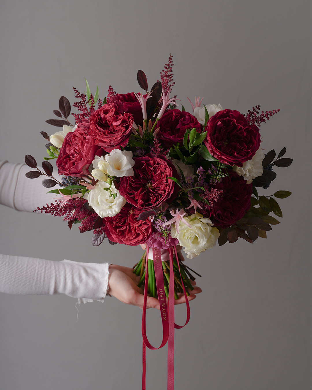 Ruth bridal bouquet with crimson Ecuadorian garden roses “Tess”, white eustomas, and Dutch greenery