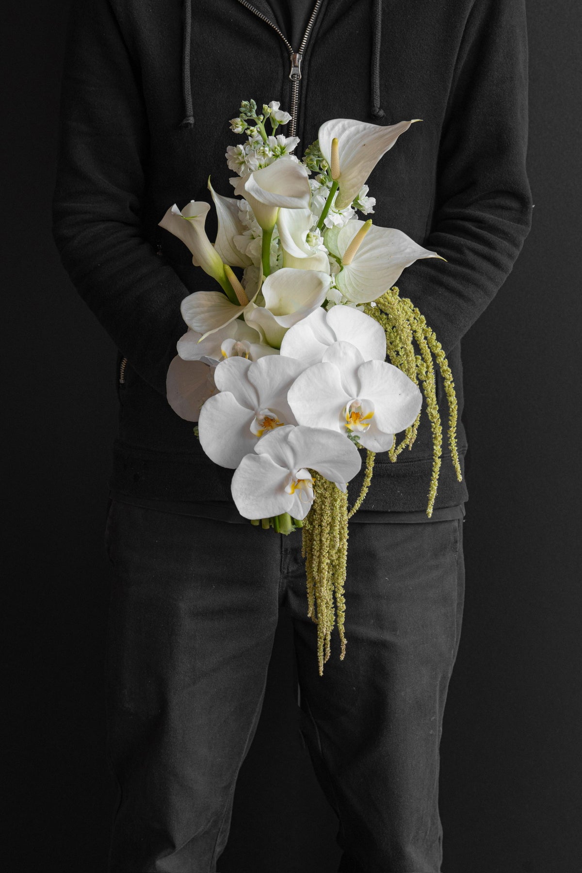 Model holding Now and Always bridal bouquet by Just Bloom Hong Kong, front view, showing white blooms and cascading green trails against black background
