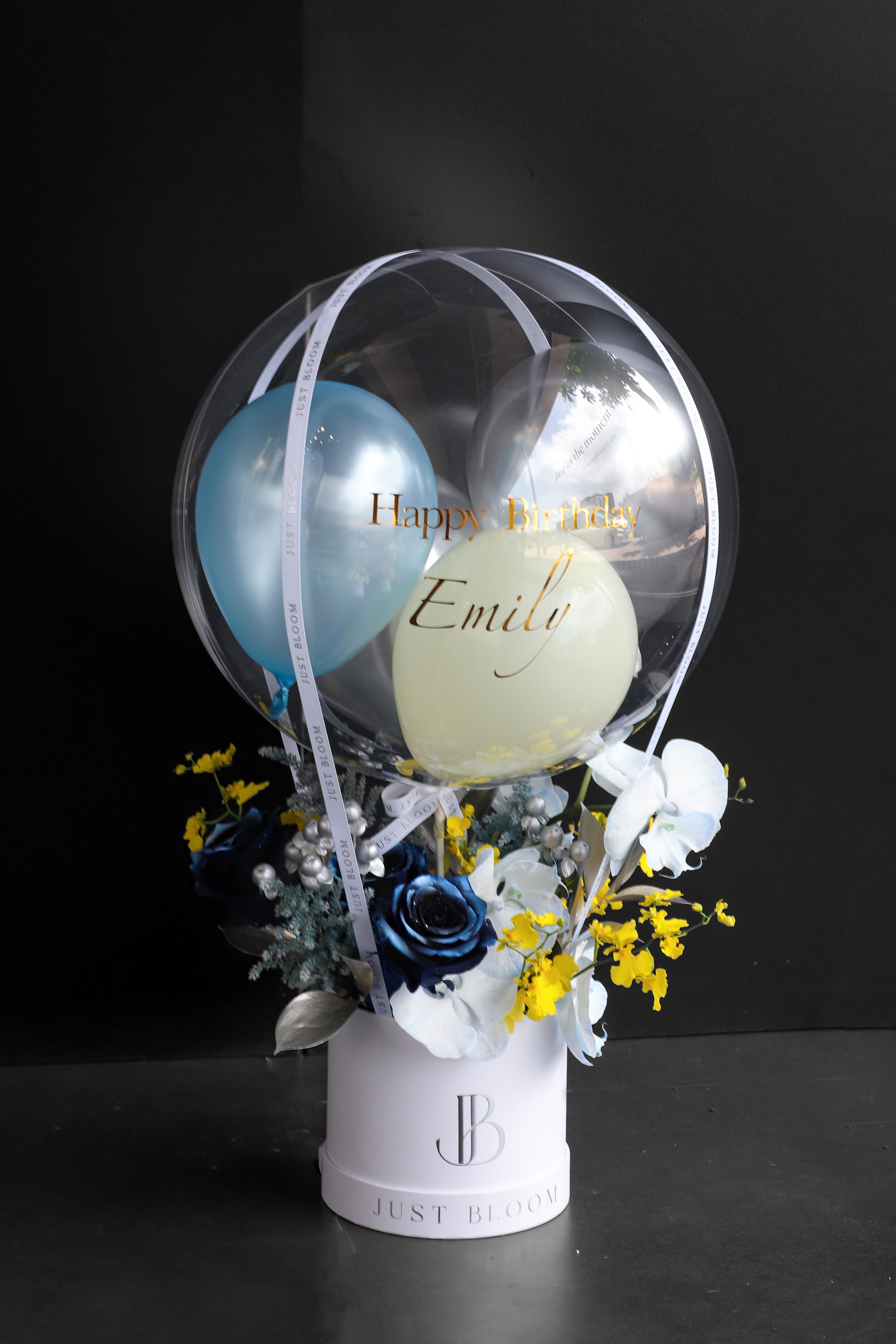 Fresh flower box with navy tinted Roses, white Phalaenopsis Orchids, yellow Dancing Orchids, and silver foliage in a white Just Bloom round box against a dark background — Just Bloom Hong Kong