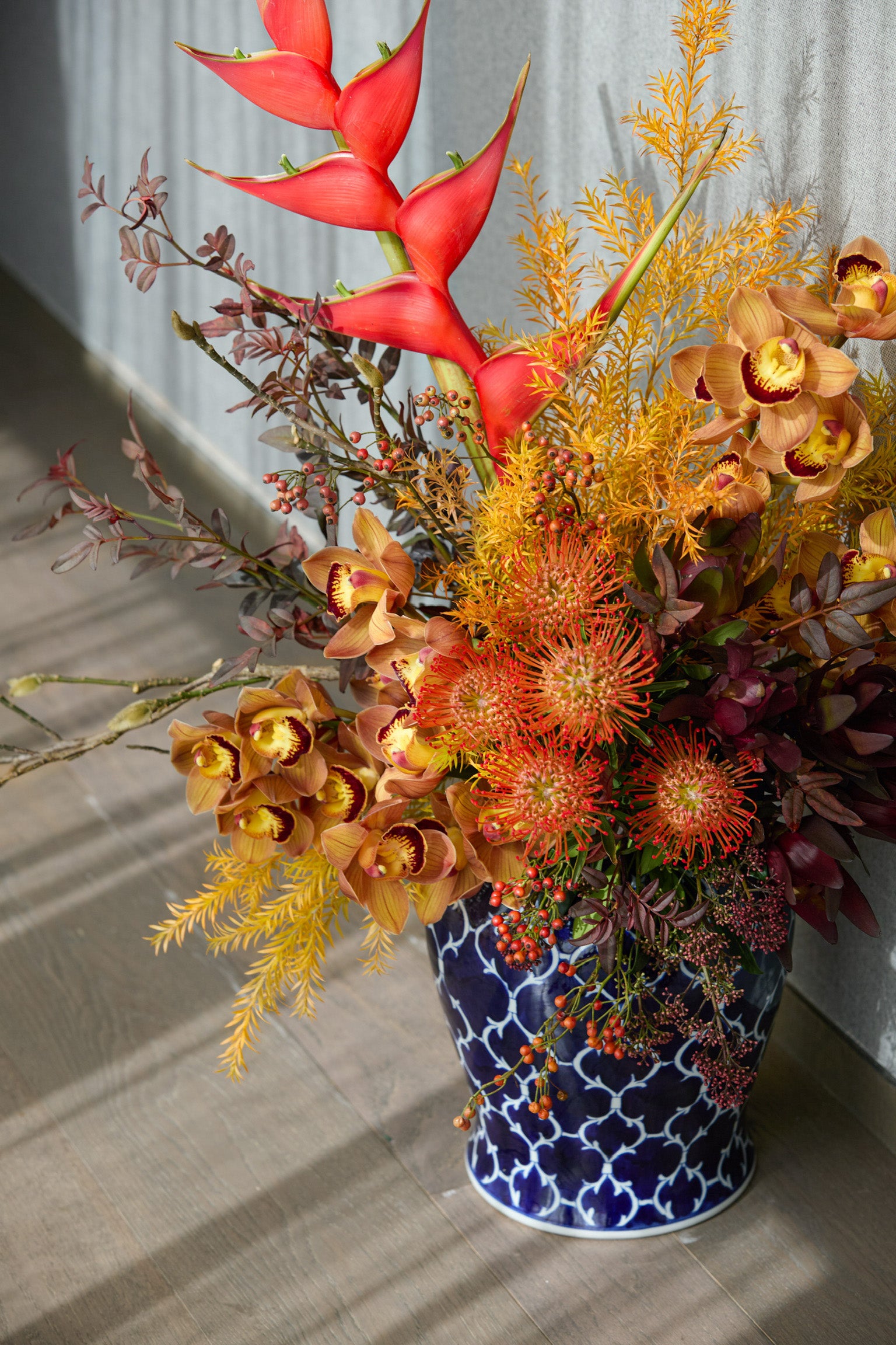 Year of the Horse exotic floral design featuring heliconias amber orchids and yellow solidago Chinese New Year arrangement