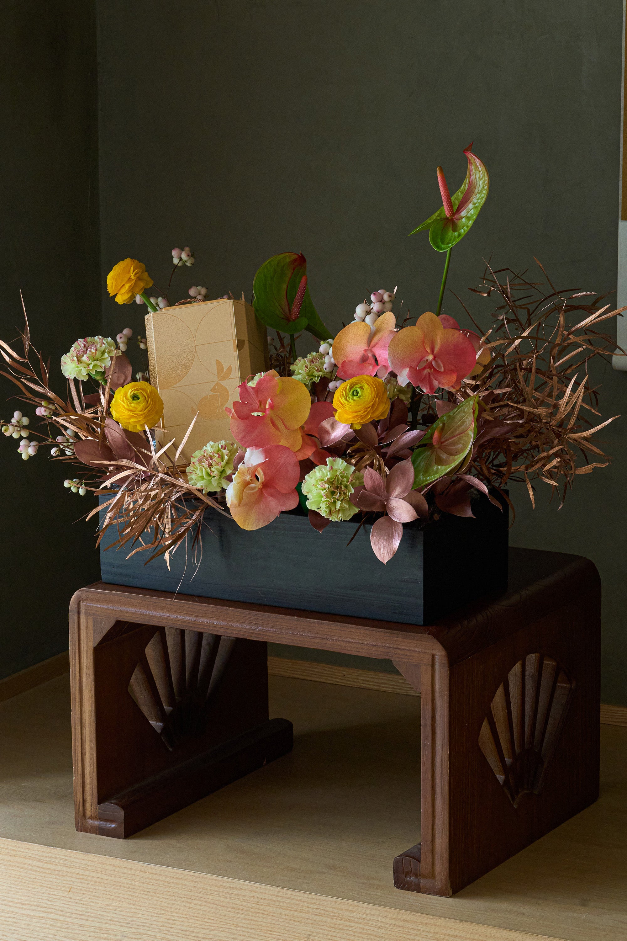 Just Bloom Radiant Moon Delight chocolate gift set with golden yellow and coral flower box arrangement on a wooden stand — Just Bloom Hong Kong