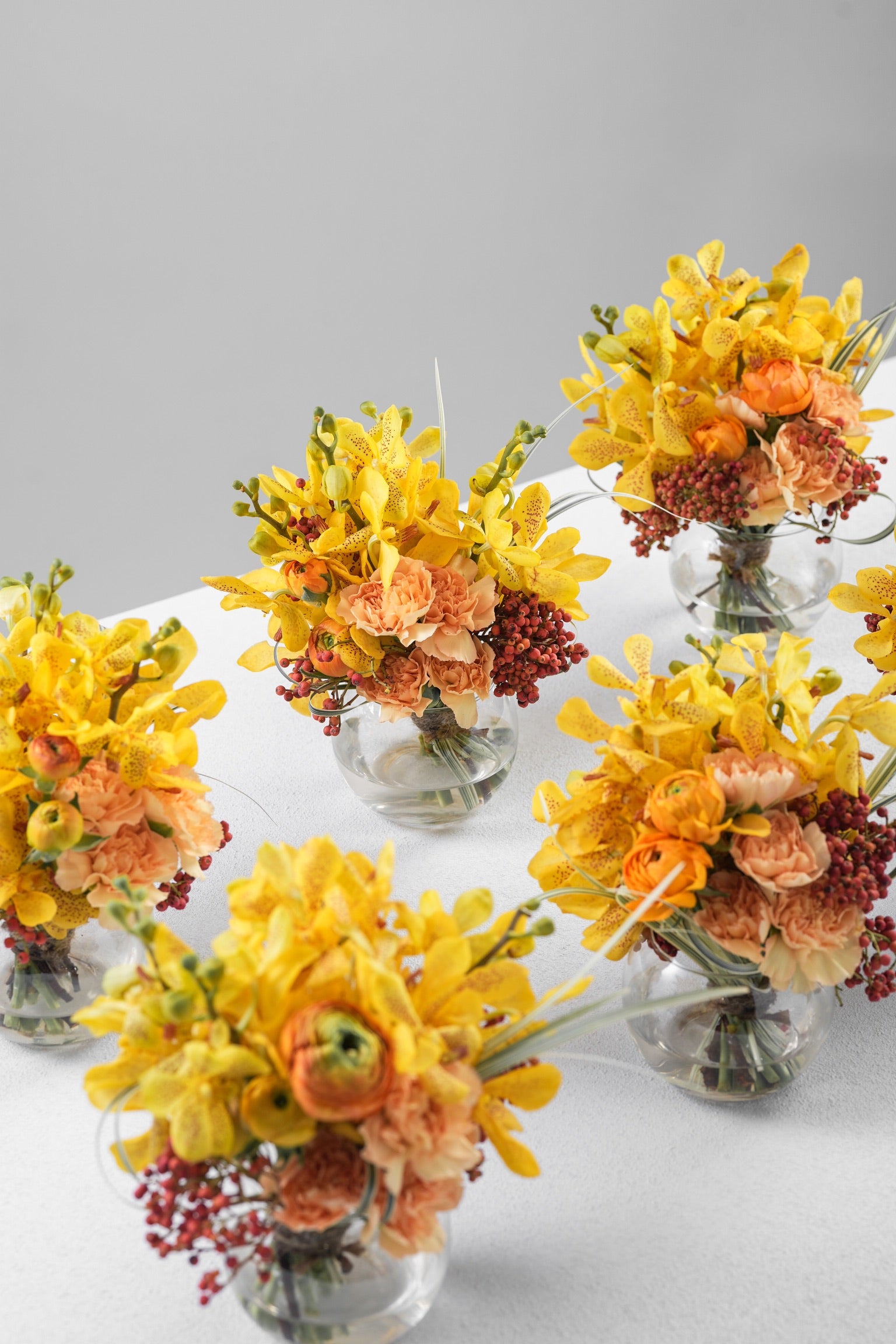 Avah Vase Arrangement with Yellow Mokara Orchids, Orange Ranunculuses, and Peach Carnations by Just Bloom Hong Kong