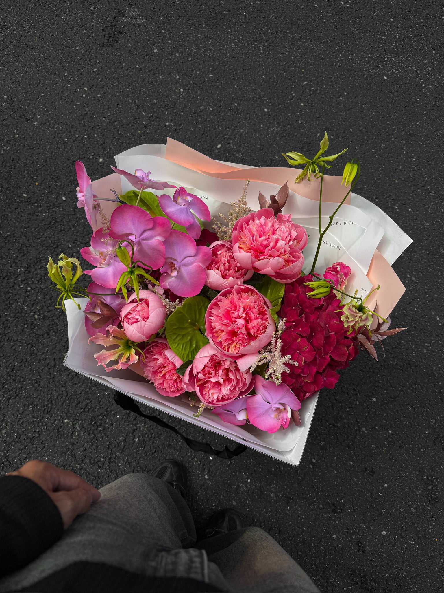 Bloom Theory luxury bouquet by Just Bloom Hong Kong photographed from above, showcasing pink peonies, purple phalaenopsis orchids, astilbes and seasonal fillers in blush pink wrapping