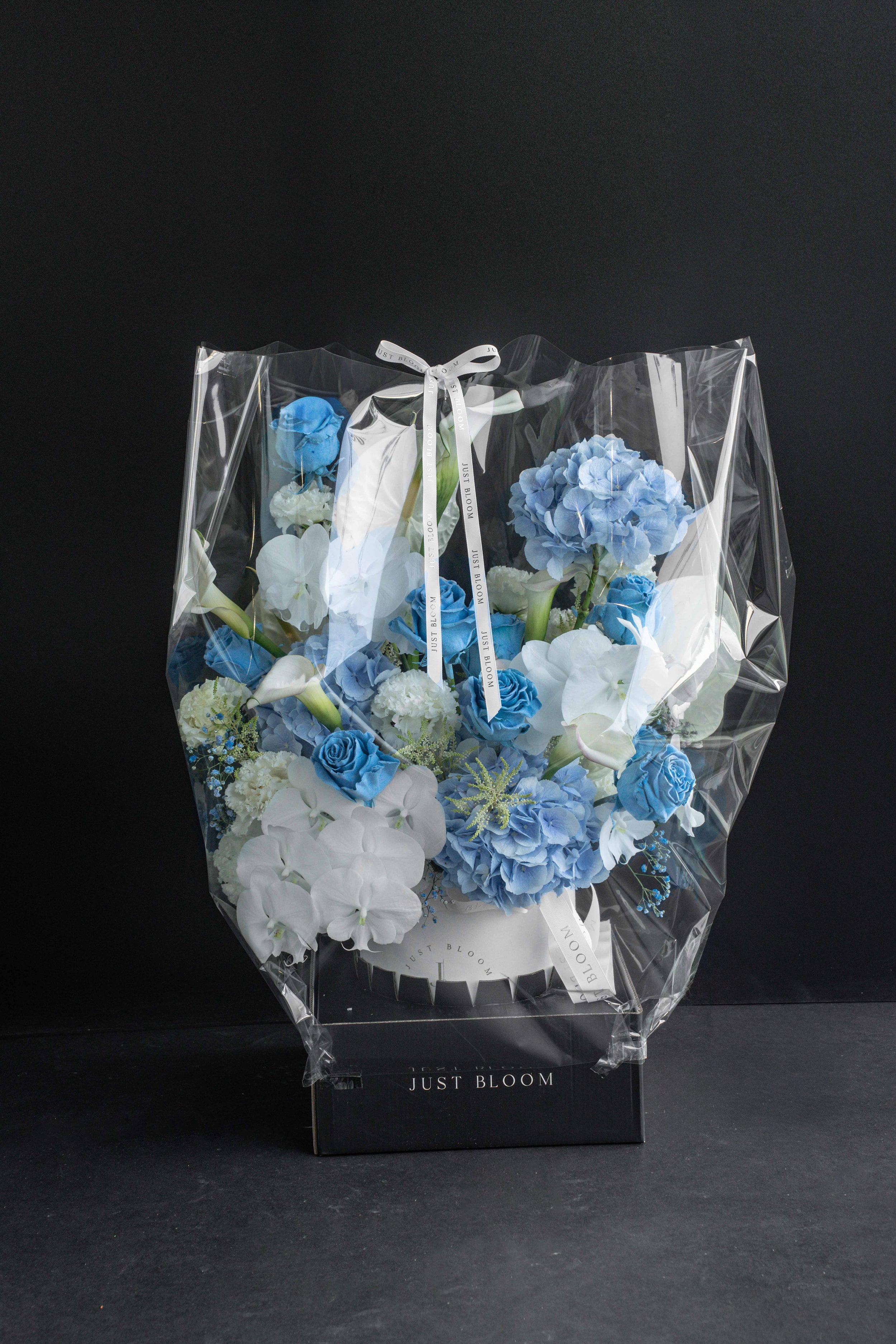 Blue Rhapsody flower box wrapped in clear cellophane with a Just Bloom ribbon, ready for delivery — Just Bloom Hong Kong