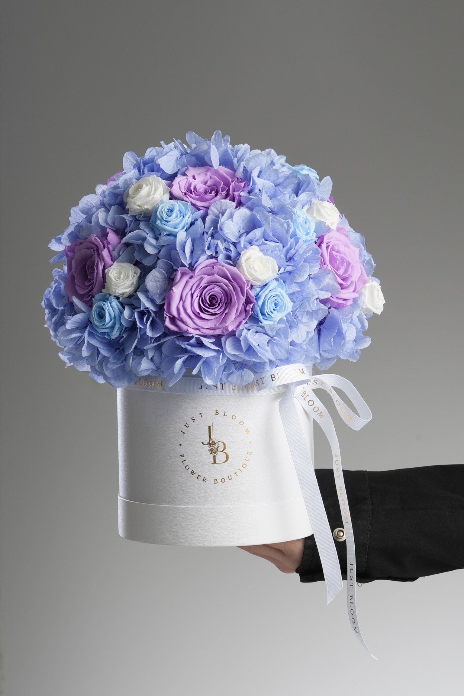 Eileen - A preserved flower box featuring blue hydrangeas, lavender, baby blue, and white roses in a soft colour palette. Elegant floral gift by Just Bloom HK