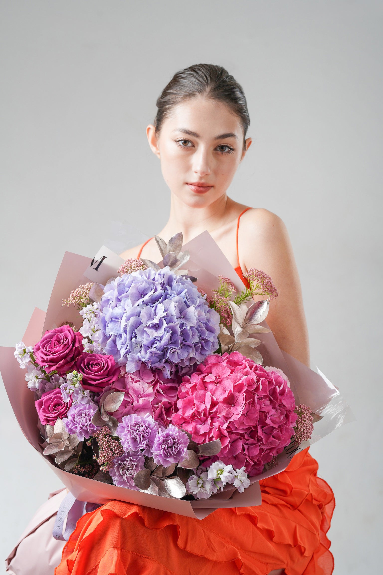 A luxurious bouquet with lavender roses, pink hydrangeas, and silver-toned foliage, wrapped in elegant style.